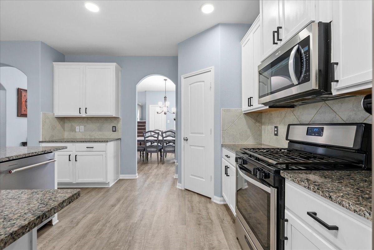 28619 Riverside Crest Lane, Huffman, TX 77336 Gas cooking, stainless appliances and a stylish backsplash make this kitchen as functional as it is inviting.