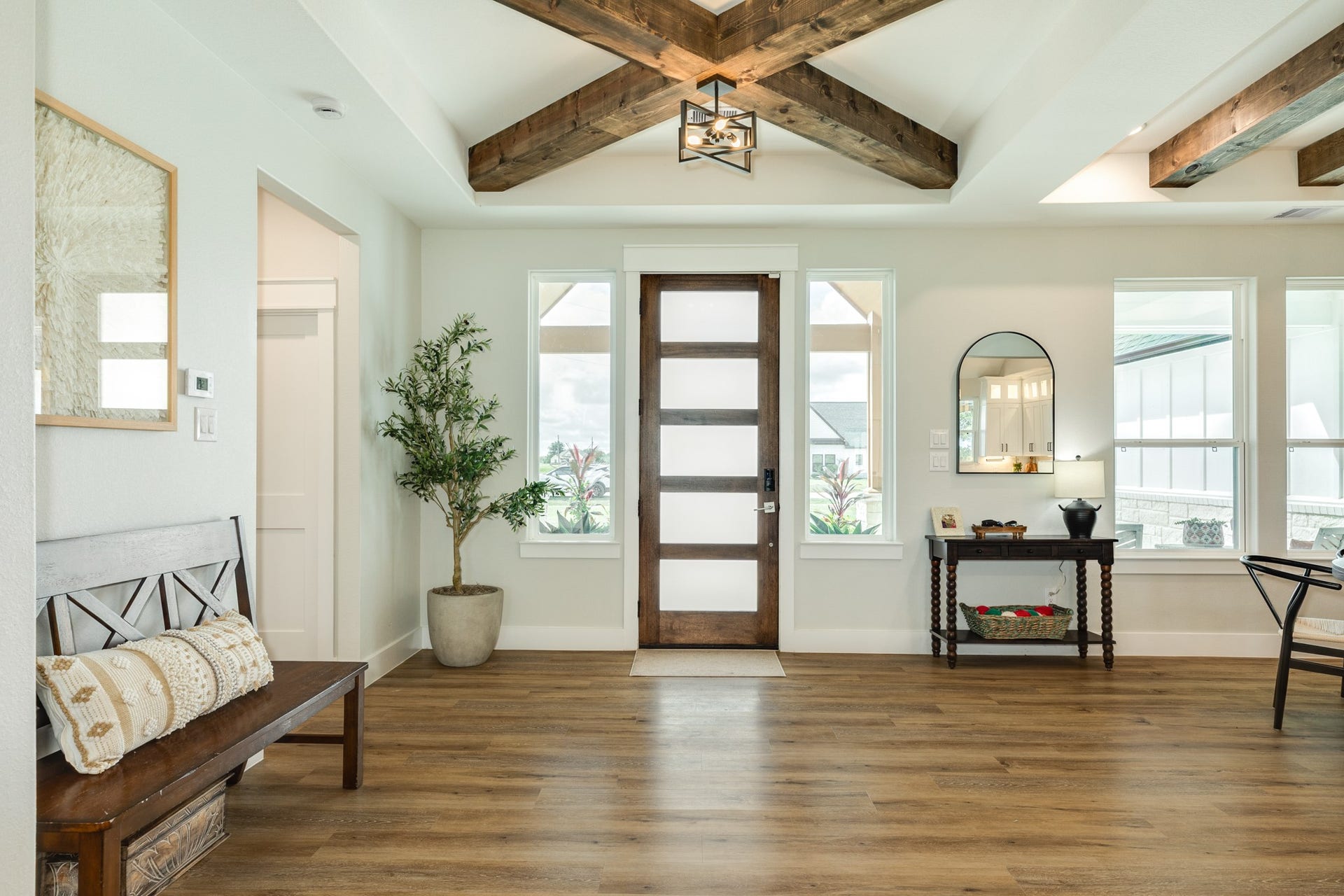 608 Angus Trail, Angleton, TX 77515 Stunning entryway with rustic wood-beamed ceiling, elegant frosted glass front door, and warm luxury vinyl flooring