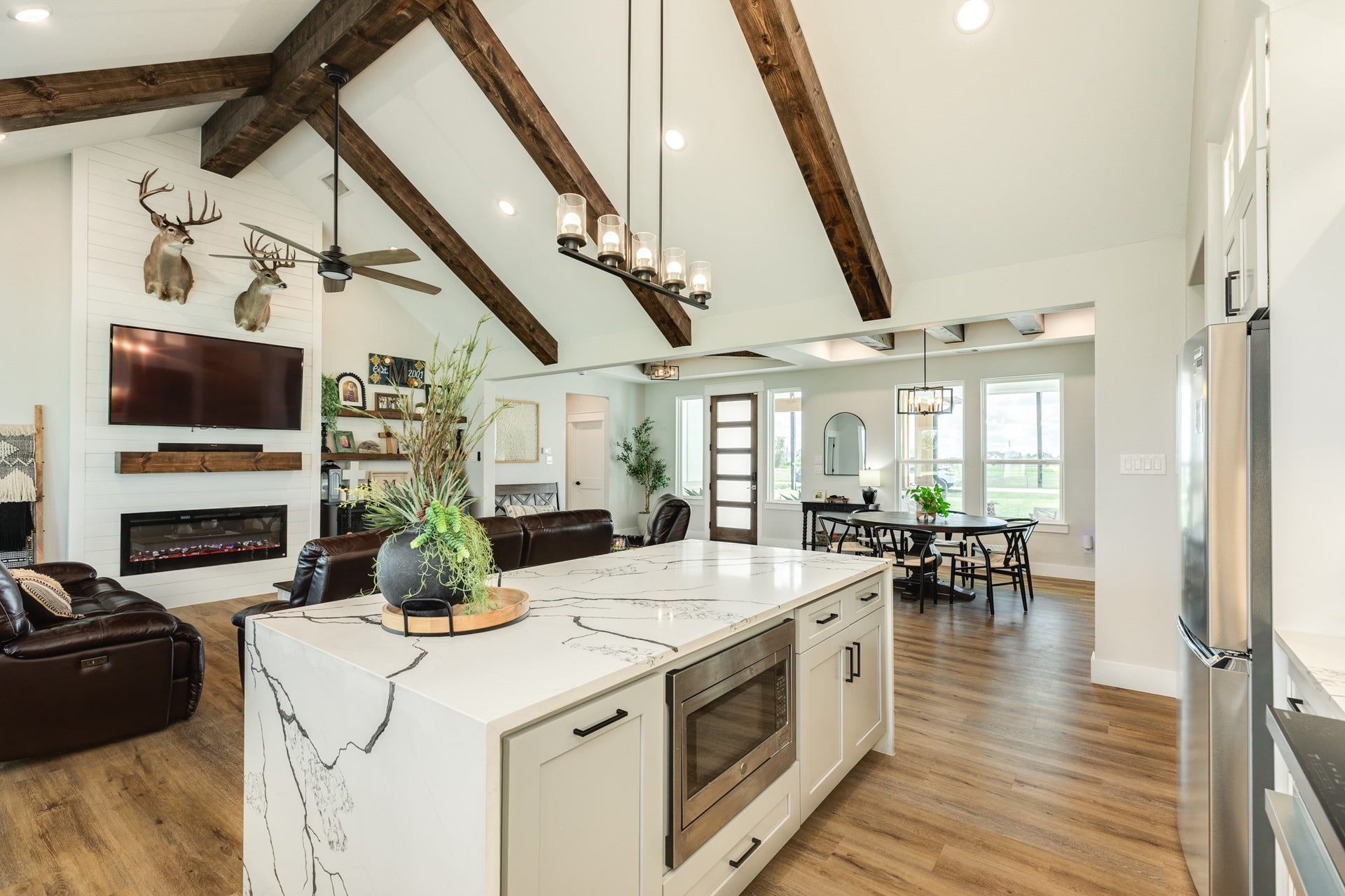 608 Angus Trail, Angleton, TX 77515 Kitchen island with Quartz Waterfall Edge, pull out trash drawer, built-in microwave and additional storage