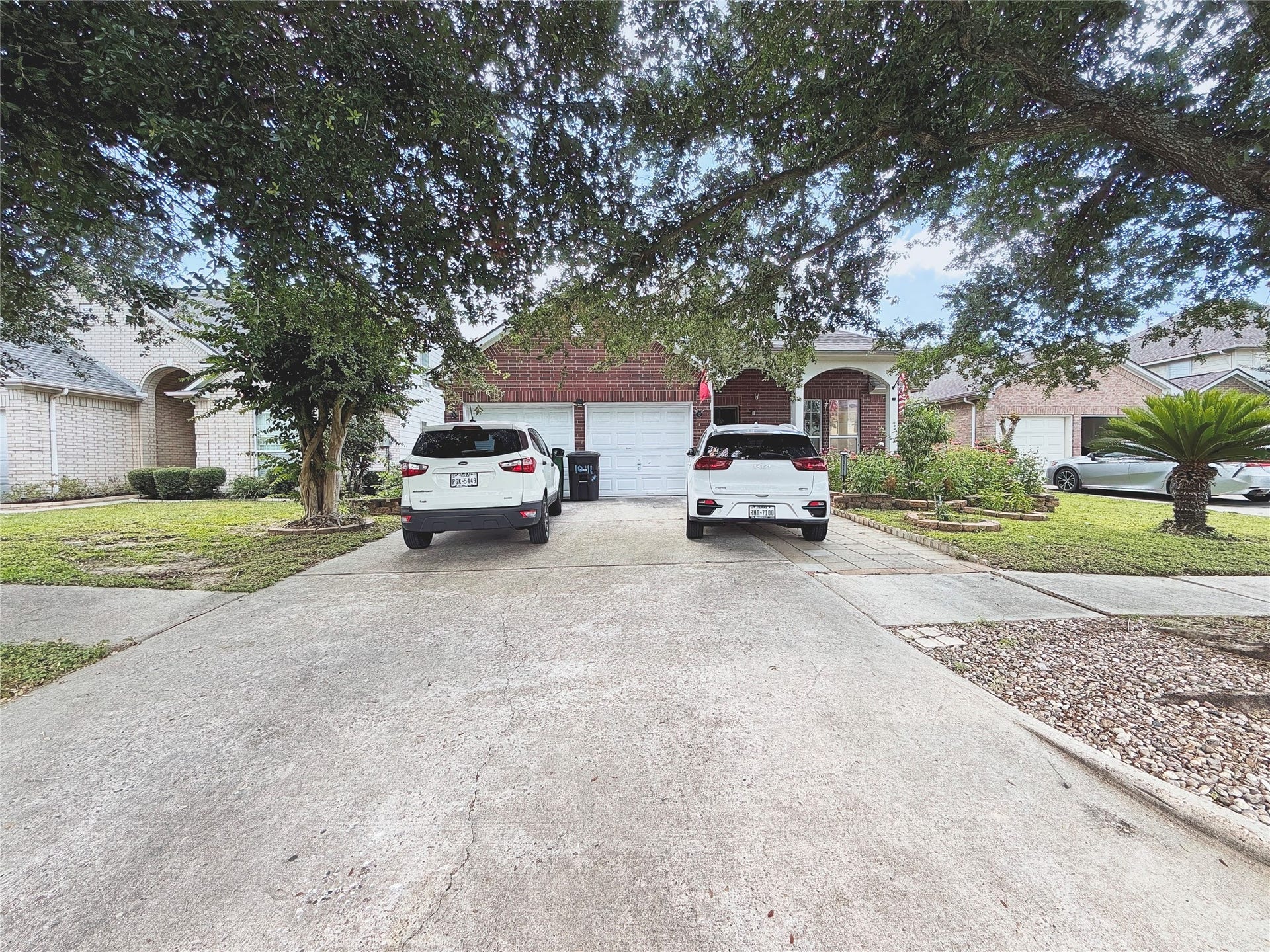 10111 San Ignacio, Houston, TX 77075 Charming brick home with a spacious driveway and mature trees, offering a welcoming front yard and attached garage.