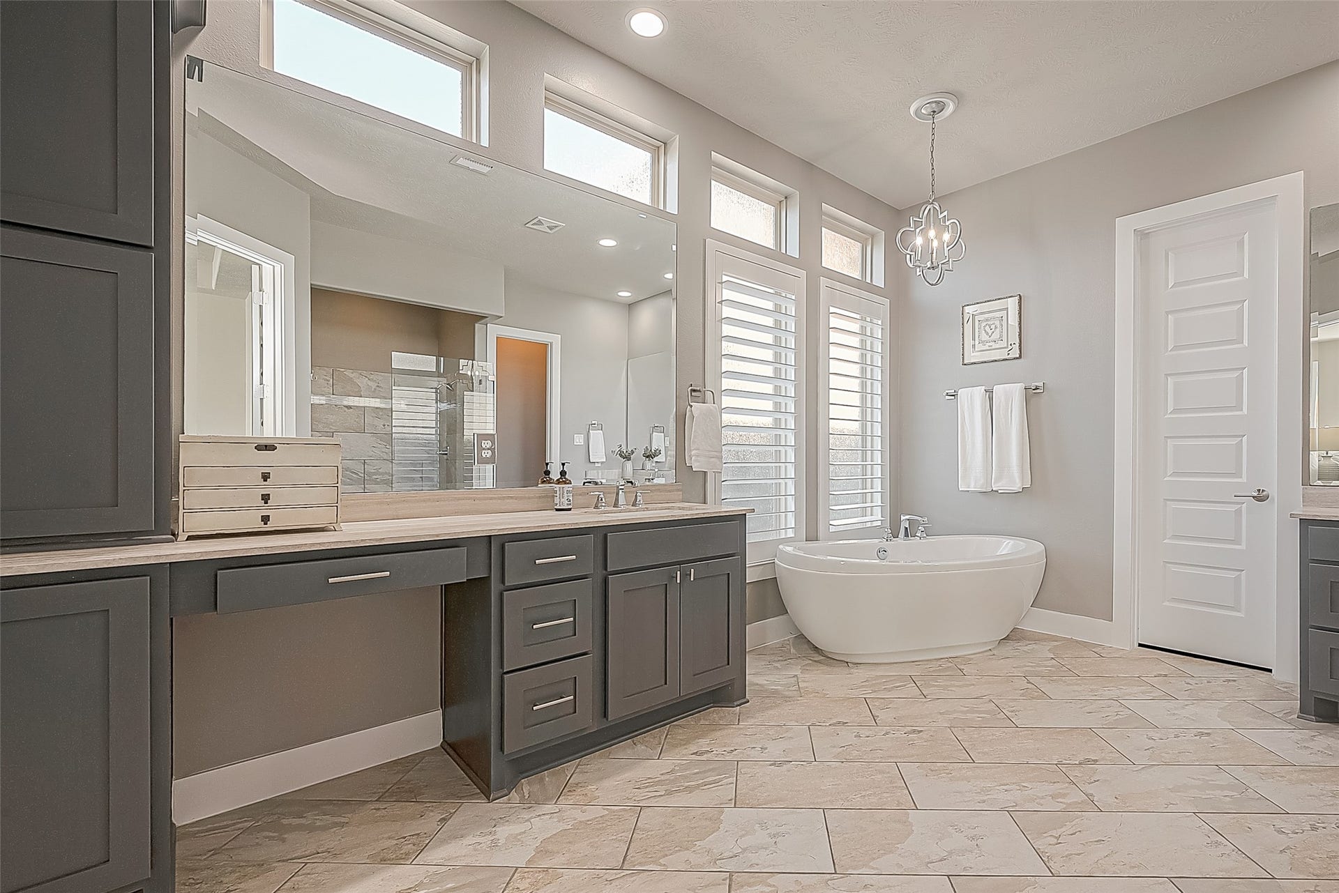 30 Argosy Bend Place, Tomball, TX 77375 Large primary bath room with large floor tile, Plantation shutters, soaker tub with pendant, dual closets and make-up area on one vanity.