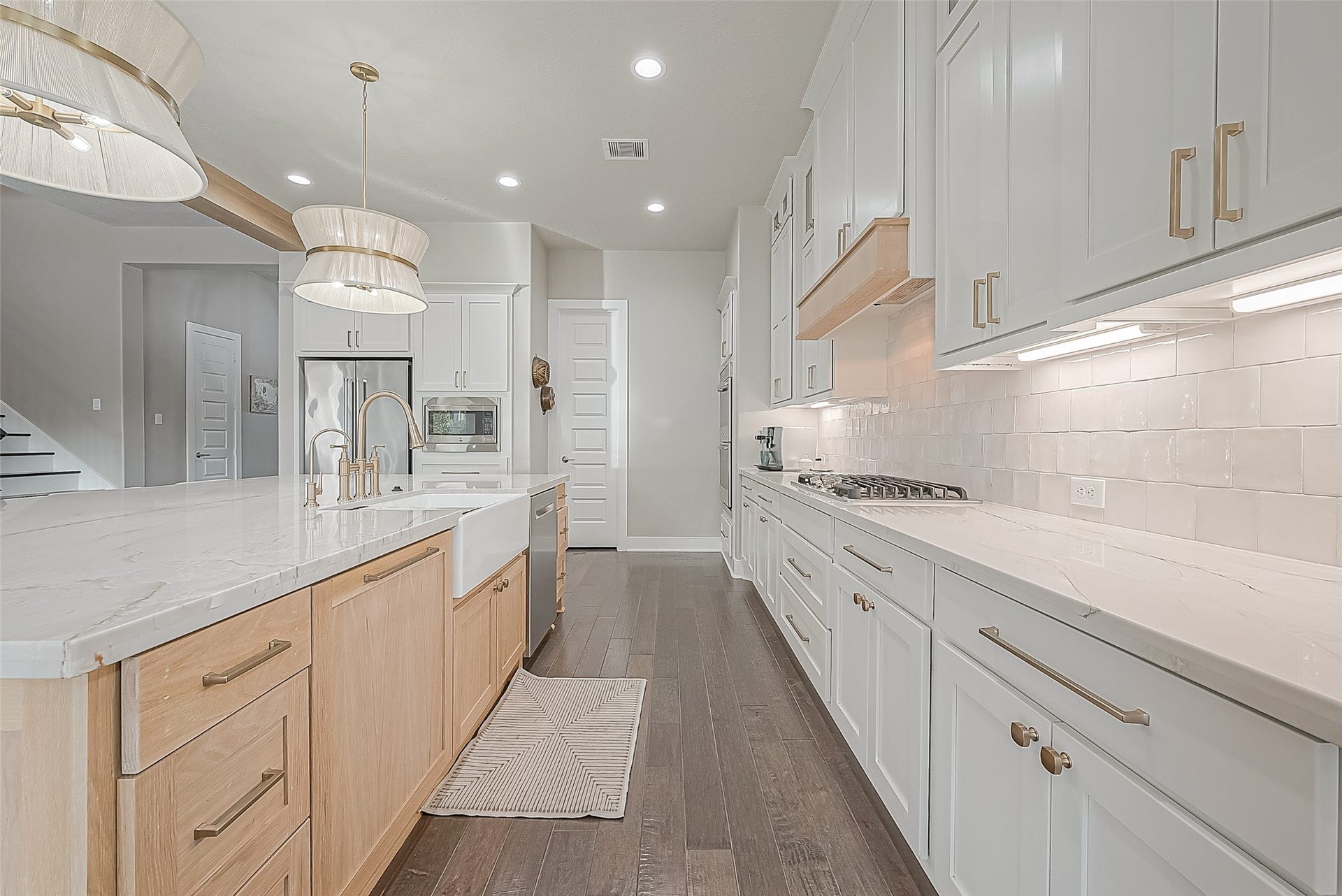 30 Argosy Bend Place, Tomball, TX 77375 The cabinets are adorned with elegant gold accents, complementing the custom lighting fixtures with a luxury feel.