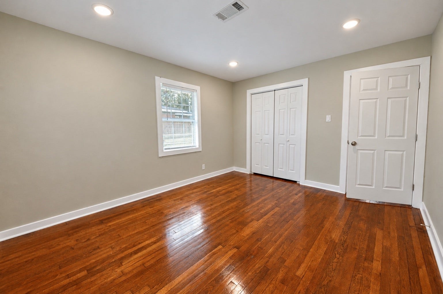 1837 Wycliffe Drive, Houston, TX 77043 Bright and spacious room featuring polished hardwood floors, neutral walls, and ample natural light from a large window.
