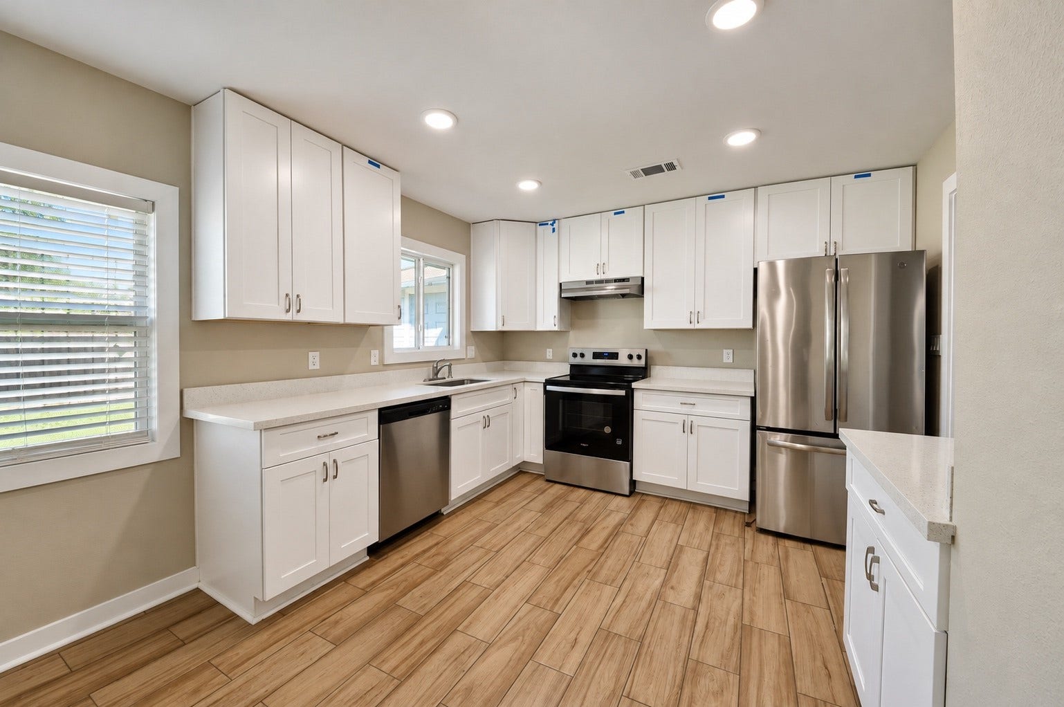 1837 Wycliffe Drive, Houston, TX 77043 Bright and modern kitchen featuring sleek stainless steel appliances, crisp white cabinetry, and warm wood-look flooring, providing a perfect blend of style and functionality.
