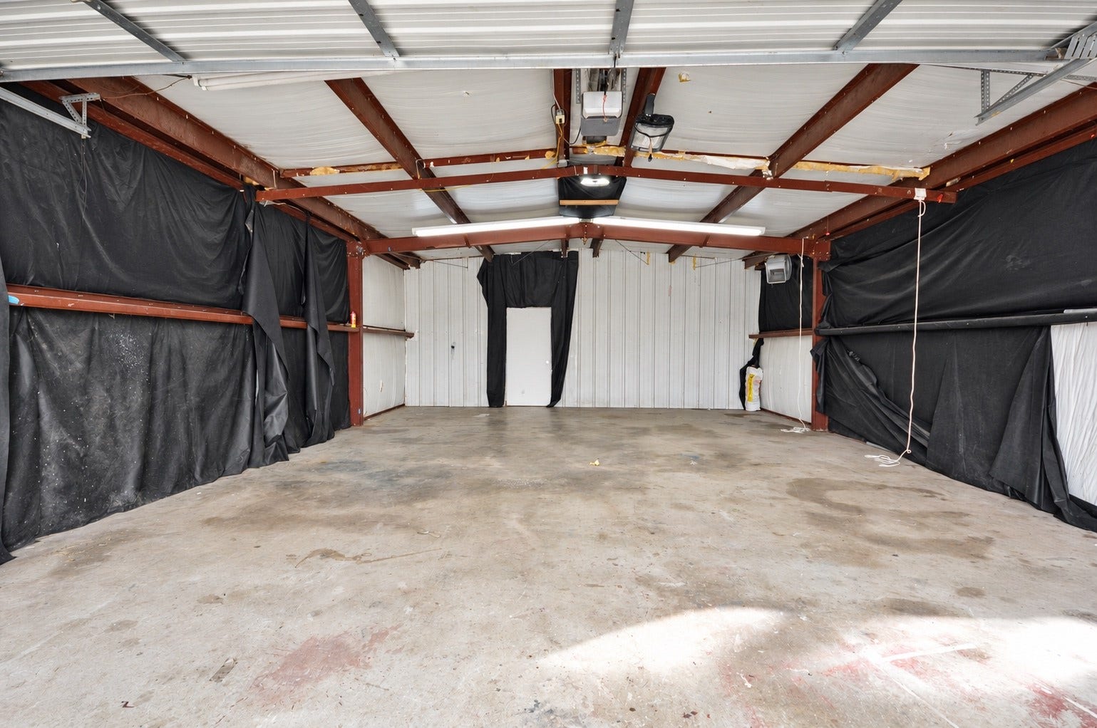 1837 Wycliffe Drive, Houston, TX 77043 Spacious garage with sturdy metal beams and ample lighting, perfect for storage or workshop use.
