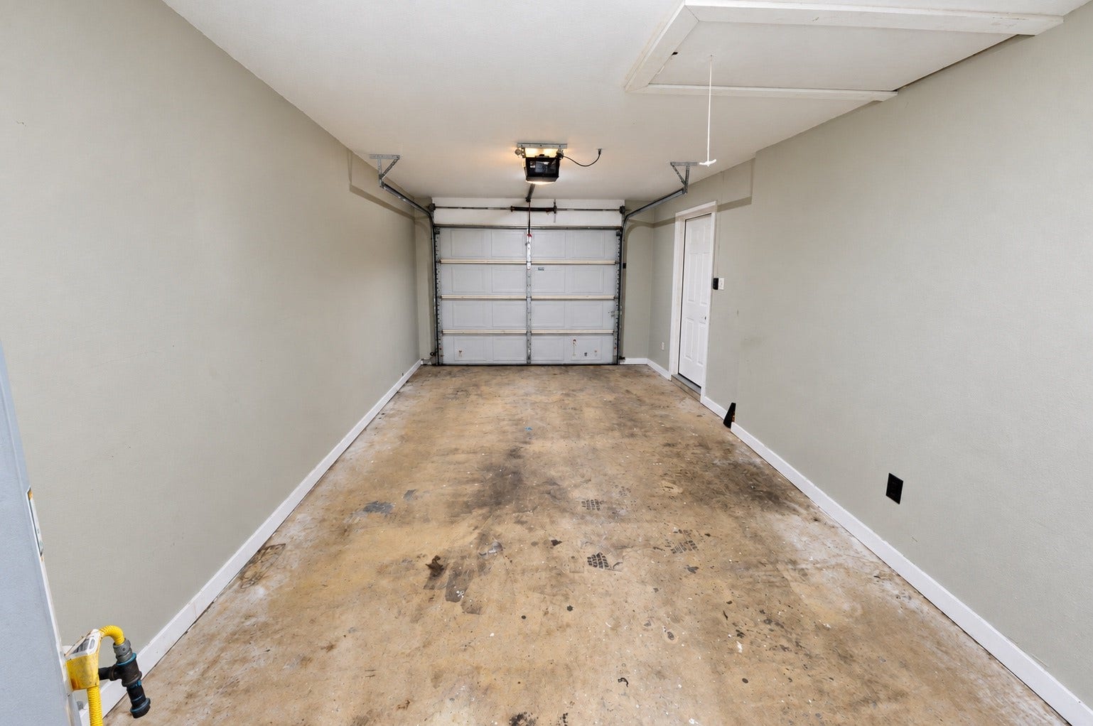 1837 Wycliffe Drive, Houston, TX 77043 Spacious single-car garage with direct access door, featuring a durable concrete floor and automatic garage door opener for convenience.