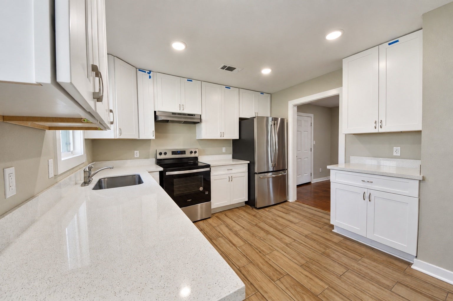 1837 Wycliffe Drive, Houston, TX 77043 Modern kitchen featuring sleek stainless steel appliances, pristine white cabinetry, and ample counter space with a bright, open layout.
