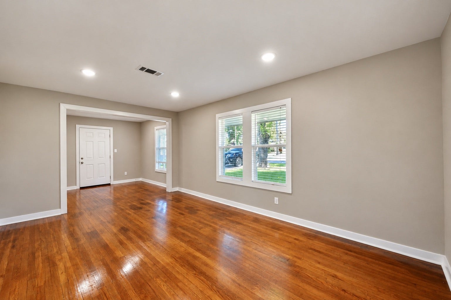 1837 Wycliffe Drive, Houston, TX 77043 Spacious living area with gleaming hardwood floors, fresh neutral paint, and abundant natural light from large windows, creating a warm and inviting atmosphere.