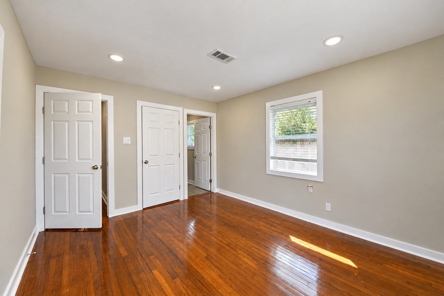 1837 Wycliffe Drive, Houston, TX 77043 Bright, spacious room with gleaming hardwood floors, neutral walls, and ample closet space, perfect for versatile living.