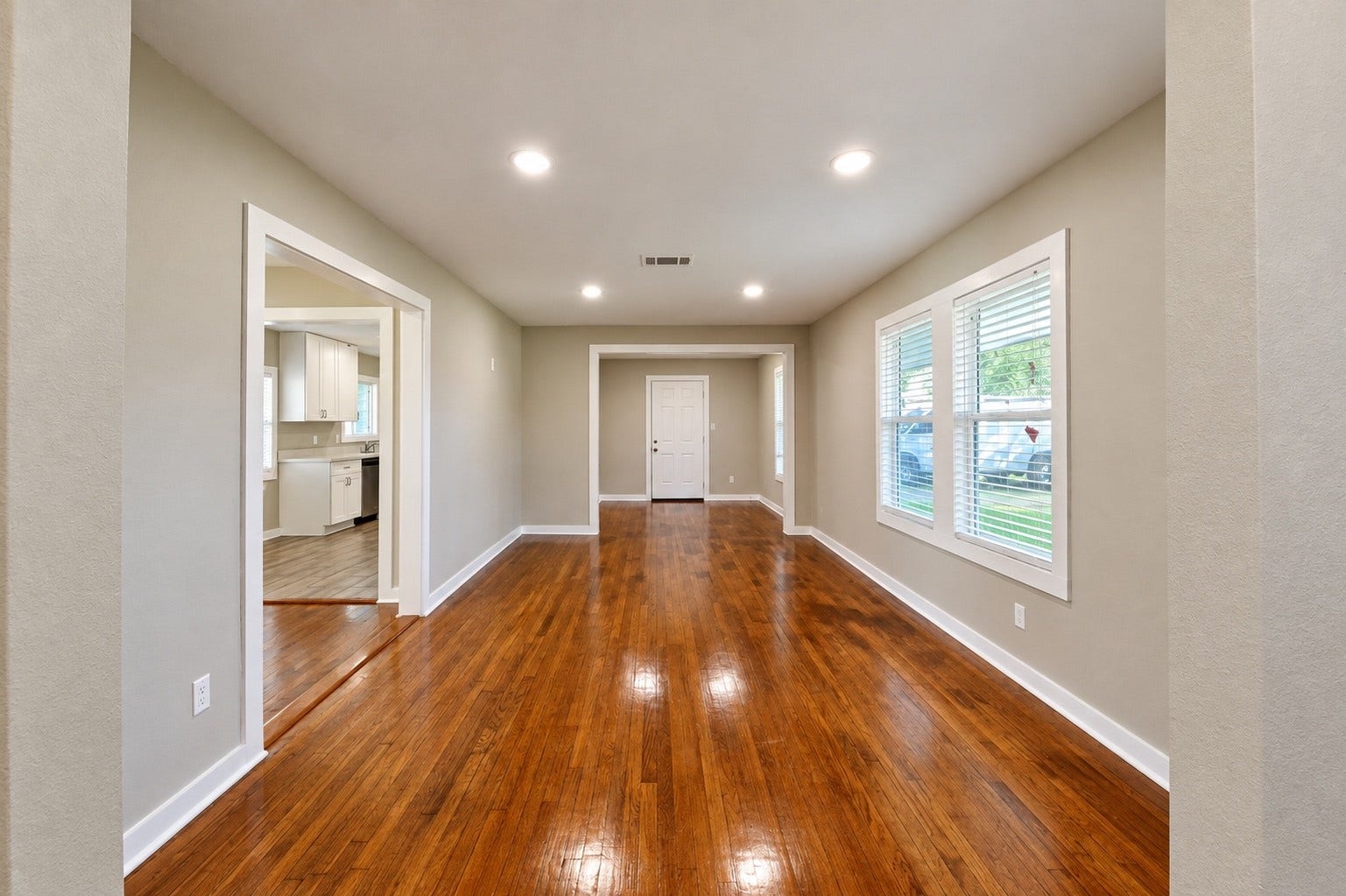 1837 Wycliffe Drive, Houston, TX 77043 Spacious living area with gleaming hardwood floors, abundant natural light from large windows, and an open layout leading to the kitchen.