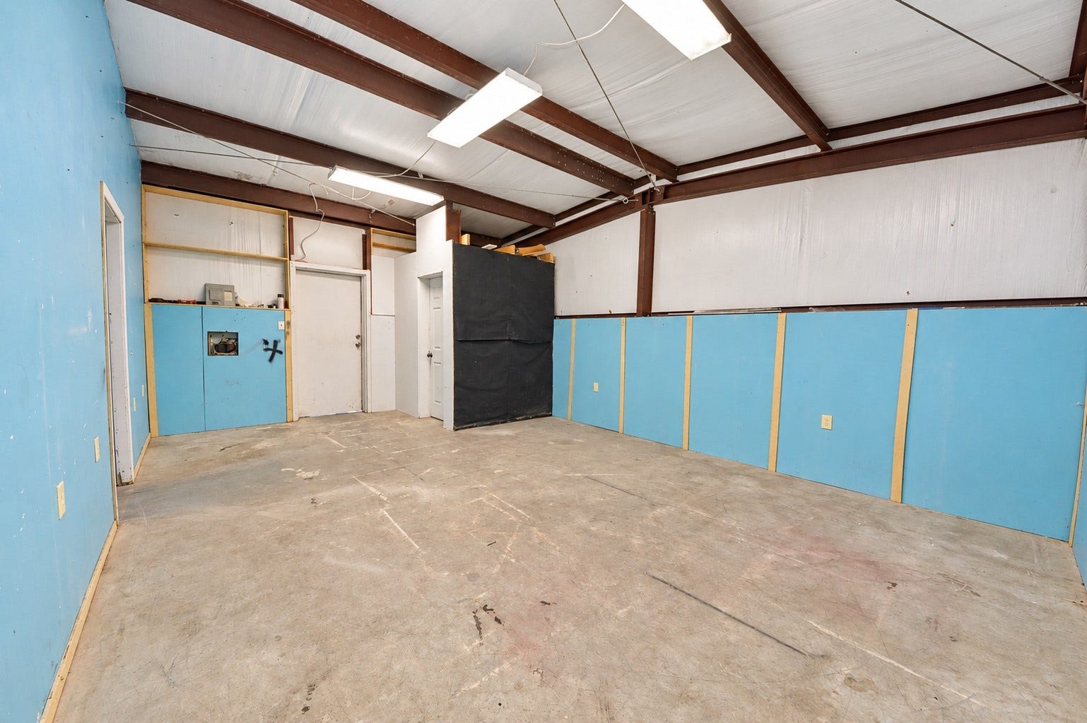 1837 Wycliffe Drive, Houston, TX 77043 Spacious utility room with exposed beams and ample lighting, offering versatile potential for customization and convenient half bath