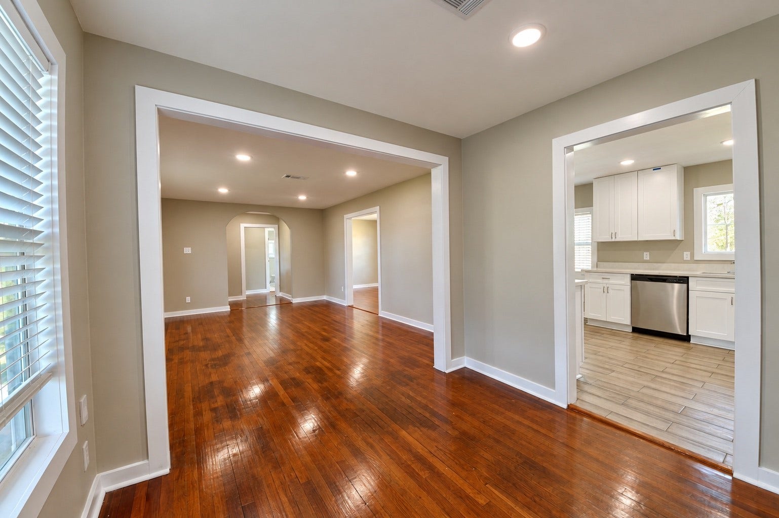 1837 Wycliffe Drive, Houston, TX 77043 Bright and inviting open-concept living area with rich hardwood floors, recessed lighting, and a seamless flow to the modern kitchen featuring sleek white cabinetry and stainless steel appliances.