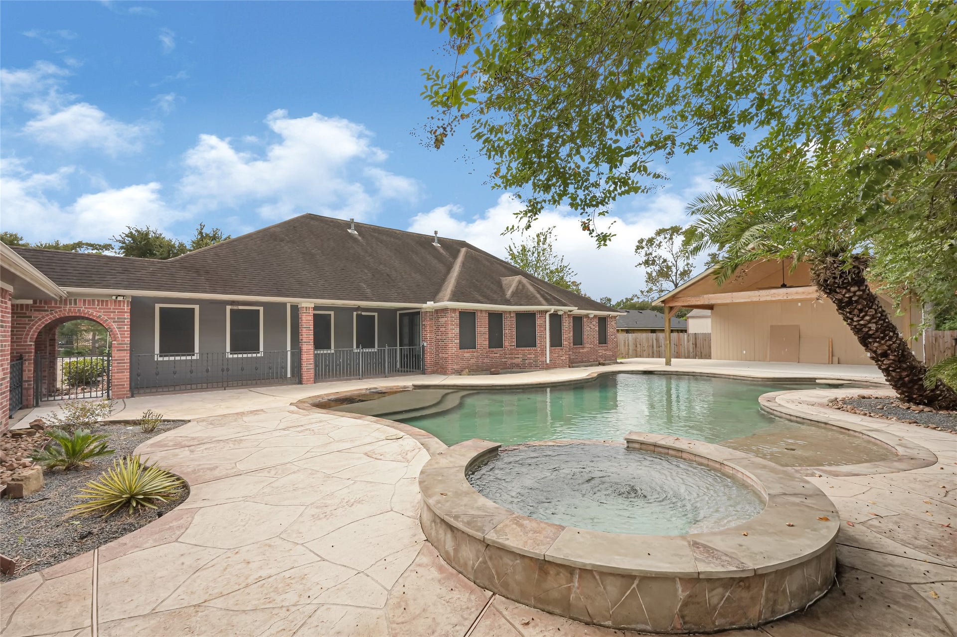 19763 Irenell Dr, Porter, TX 77365 Experience luxurious outdoor living with this beautiful backyard oasis, featuring a sparkling pool, spa, and spacious patio area perfect for relaxation and entertaining.