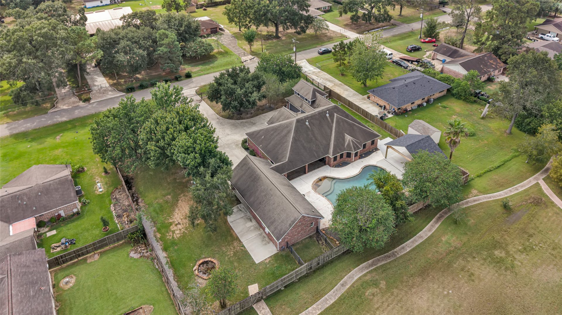 19763 Irenell Dr, Porter, TX 77365 Spacious property featuring a large, inviting pool, surrounded by lush greenery and a private fenced yard, ideal for family gatherings and outdoor enjoyment.