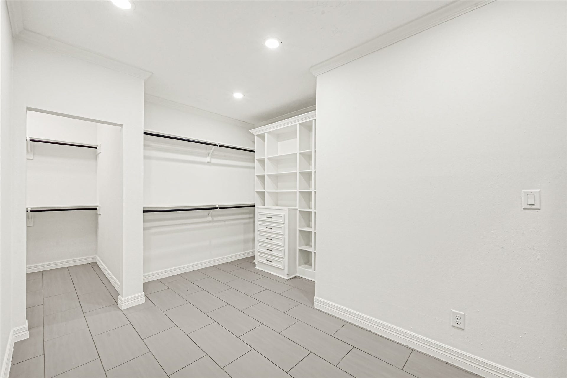 19763 Irenell Dr, Porter, TX 77365 Spacious walk-in closet featuring ample shelving, built-in drawers, and elegant tile flooring for a modern, organized storage solution.