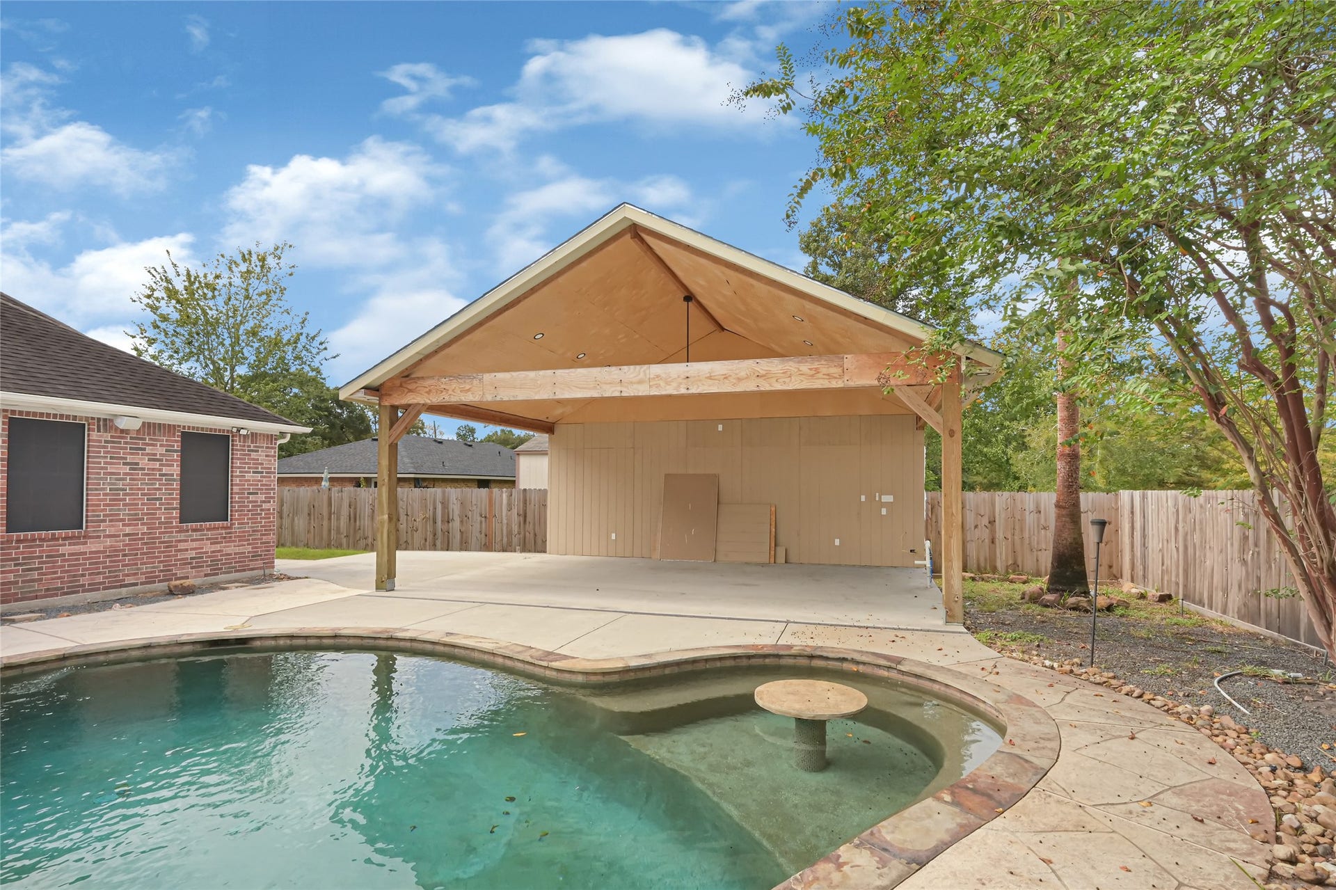 19763 Irenell Dr, Porter, TX 77365 Enjoy outdoor living with this spacious covered patio overlooking a sparkling pool, perfect for entertaining or relaxing in privacy.