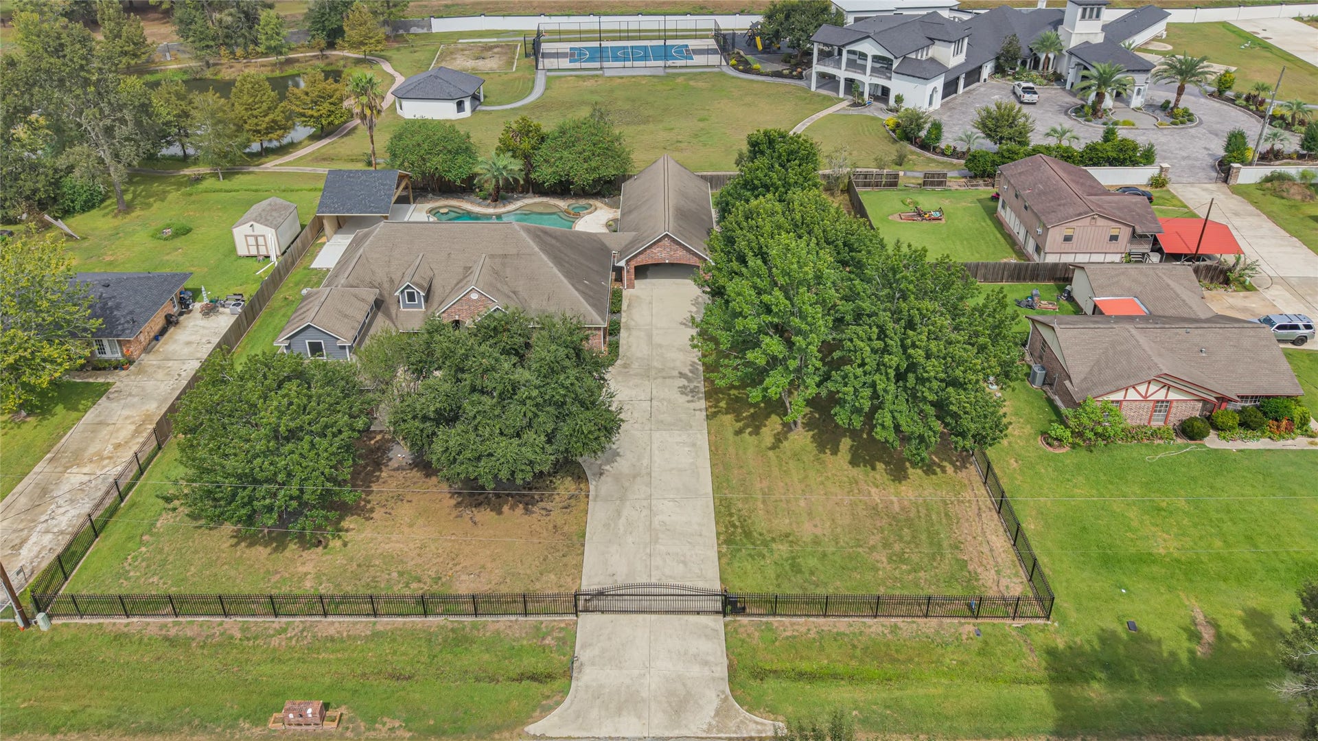 19763 Irenell Dr, Porter, TX 77365 Expansive property featuring a spacious driveway leading to a charming home with a pool, nestled in a lush, tree-lined setting. Perfect for enjoying outdoor activities and privacy.