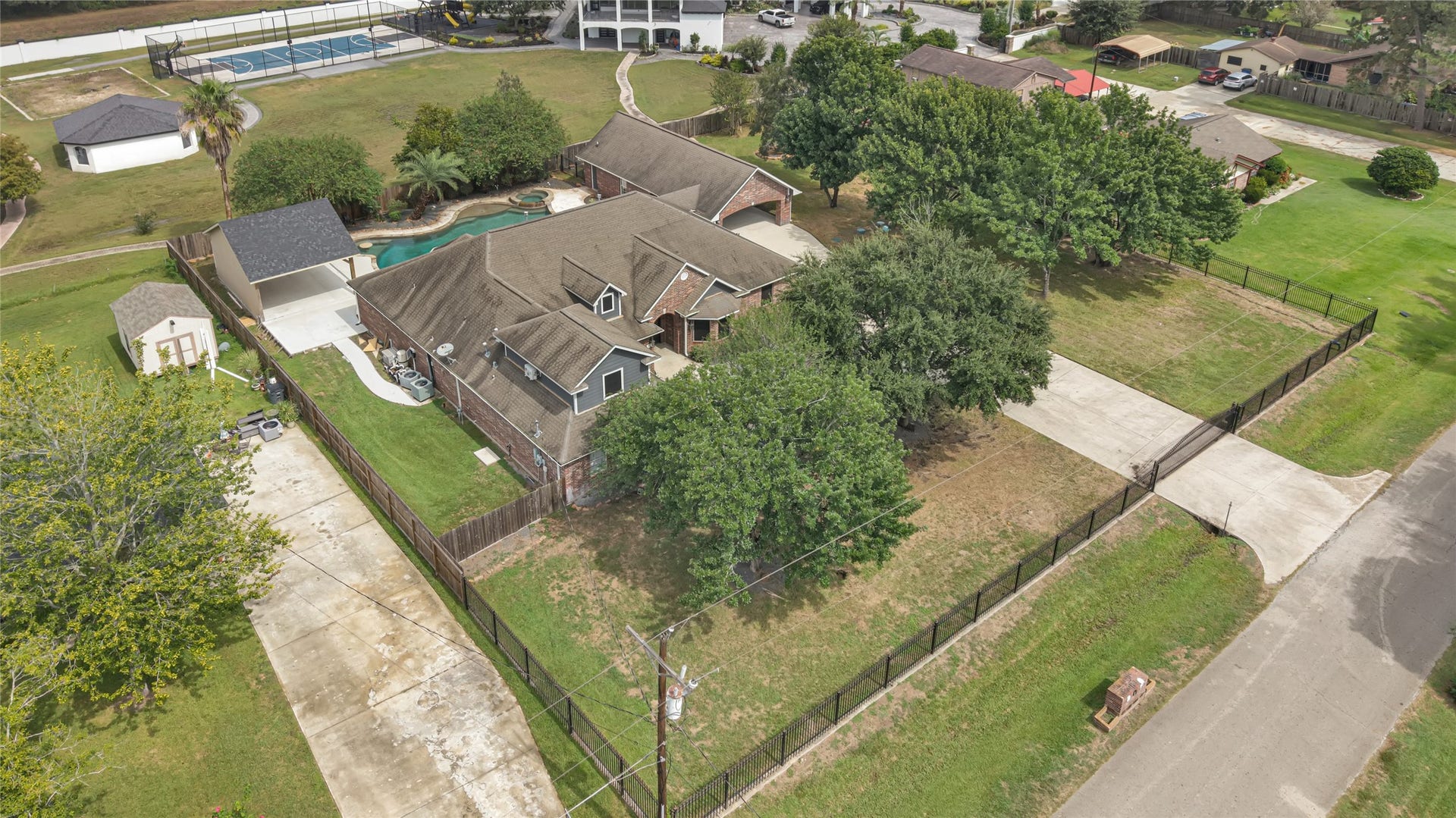 19763 Irenell Dr, Porter, TX 77365 Expansive property featuring a charming brick home with a lush, fenced yard, a spacious driveway, and a sparkling pool, offering the perfect blend of privacy and outdoor enjoyment.