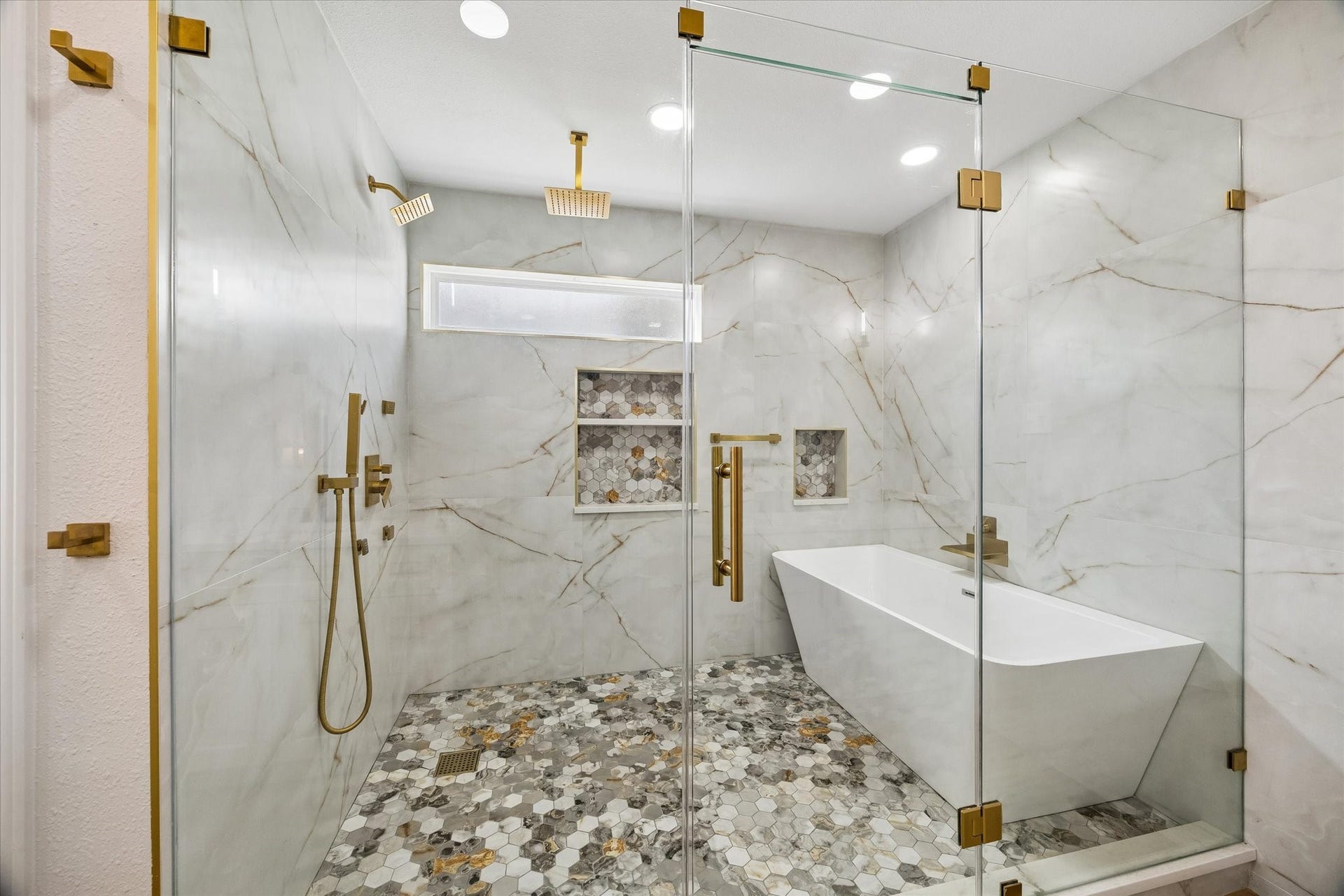 2302 Ashford Hollow Lane, Houston, TX 77077 Luxurious bathroom featuring a spacious glass-enclosed shower with dual rain showerheads, elegant walls, and a modern freestanding tub.