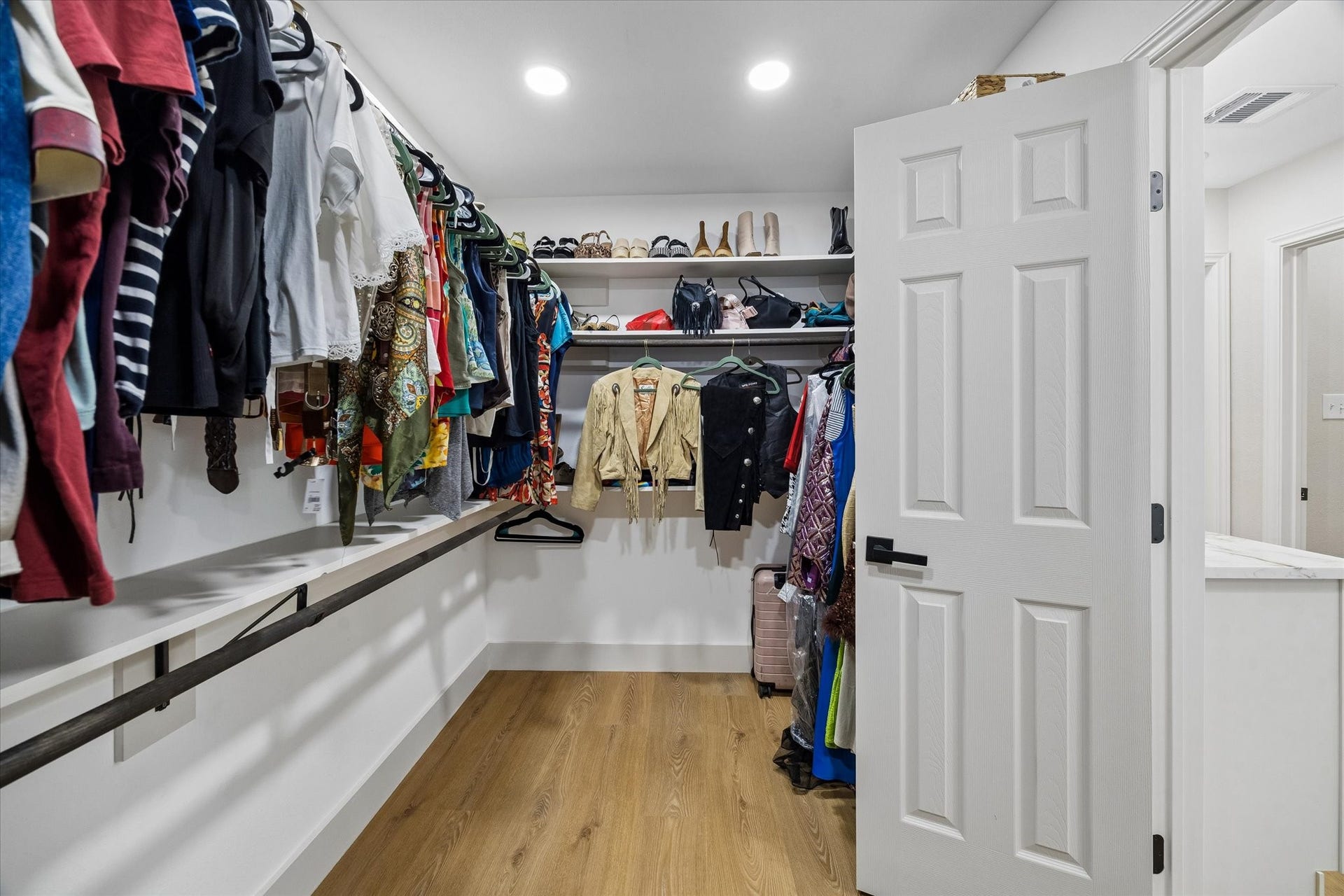 2302 Ashford Hollow Lane, Houston, TX 77077 Spacious walk-in closet with ample hanging space, shelving for shoes and accessories, and elegant wood flooring.