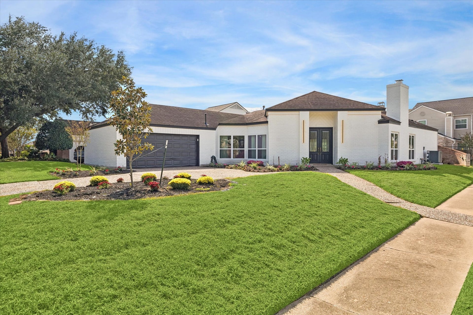2302 Ashford Hollow Lane, Houston, TX 77077 Charming single-story home on a corner lot with a modern exterior, featuring a spacious two-car garage, well-maintained landscaping, and a welcoming entryway.