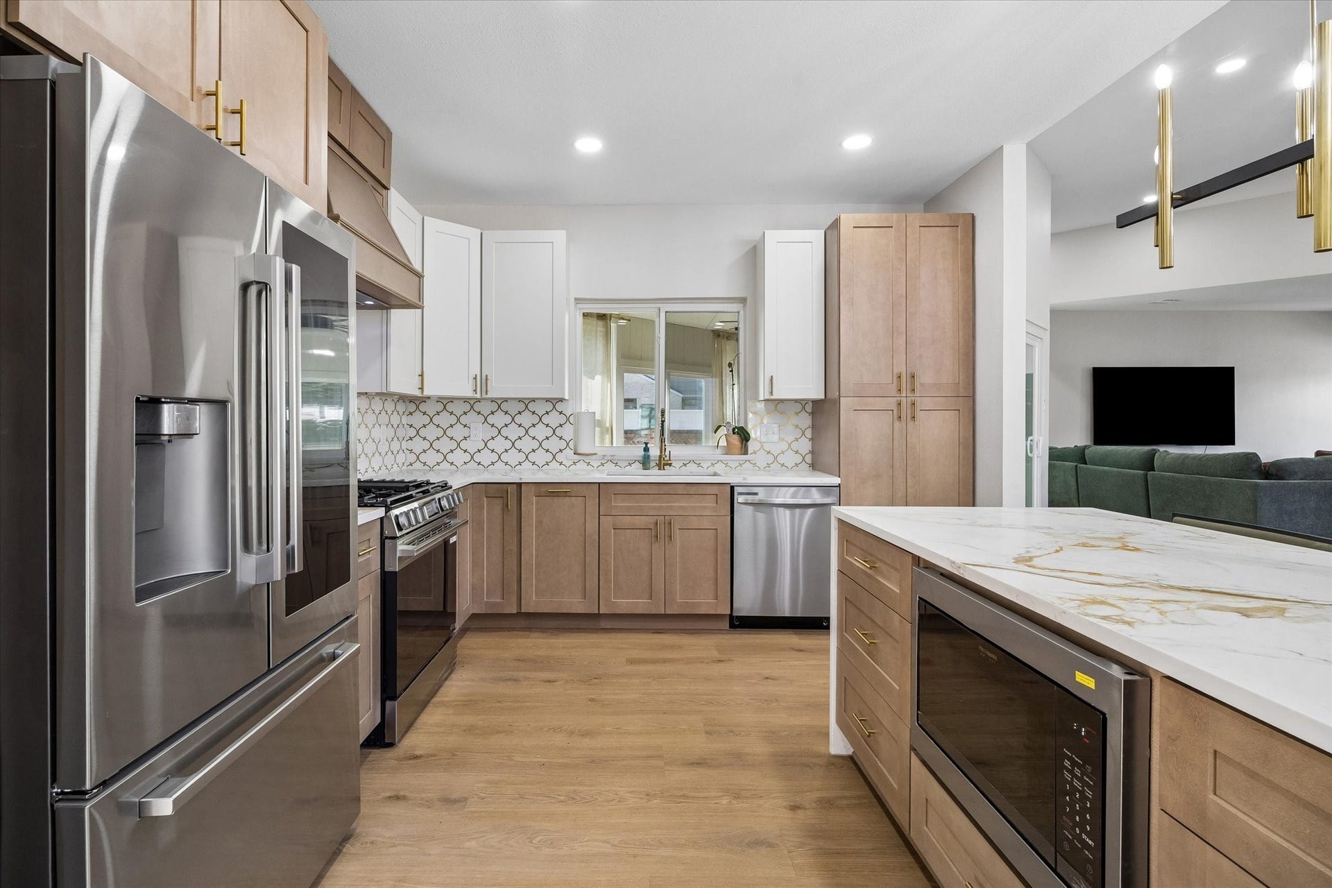 2302 Ashford Hollow Lane, Houston, TX 77077 Modern kitchen with sleek stainless steel appliances, elegant light wood cabinetry, and a spacious island featuring a quartz countertop.