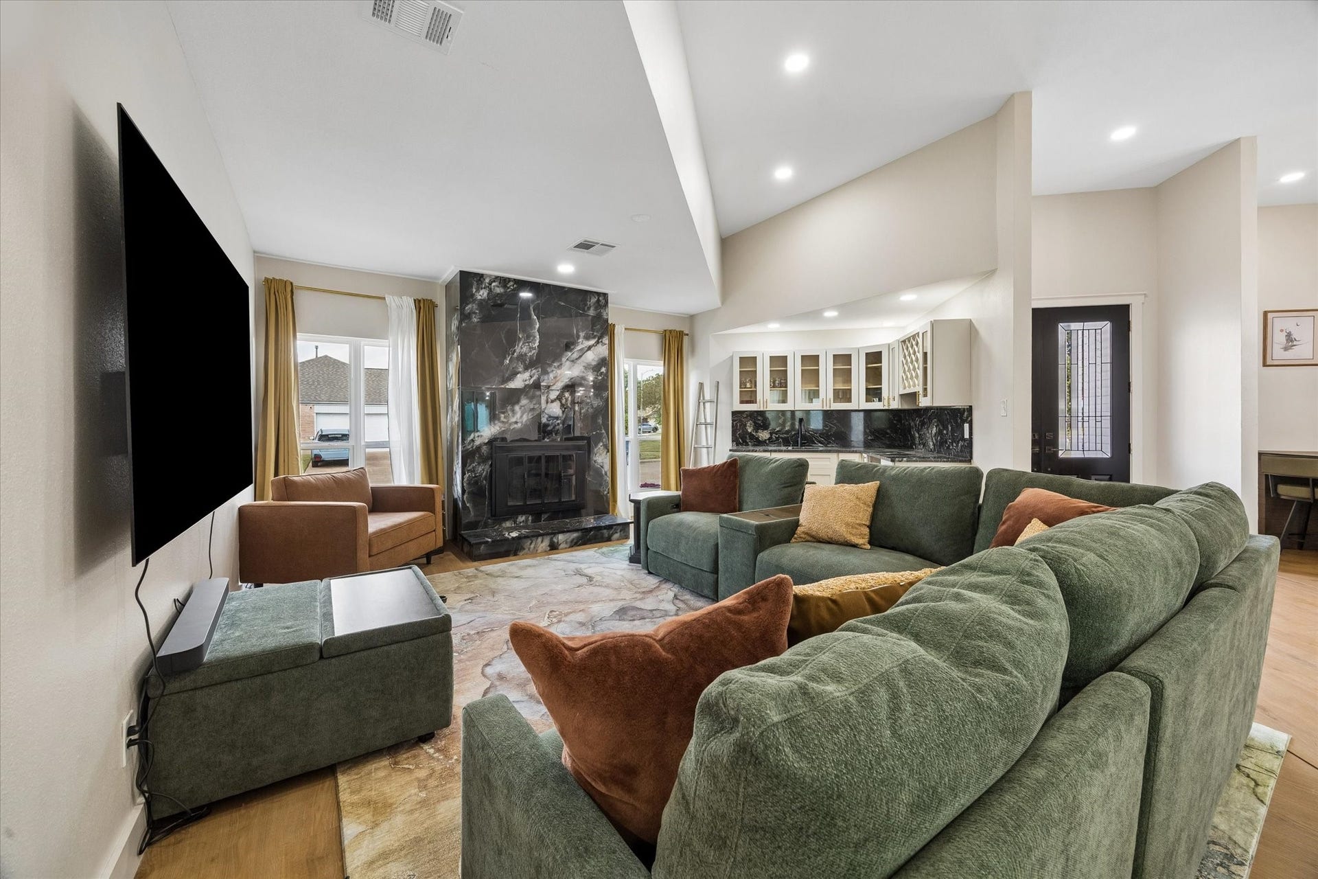 2302 Ashford Hollow Lane, Houston, TX 77077 This spacious living room with a sleek black marble gas log fireplace, wet bar and abundant natural light from large windows is the heartbeat of this home.