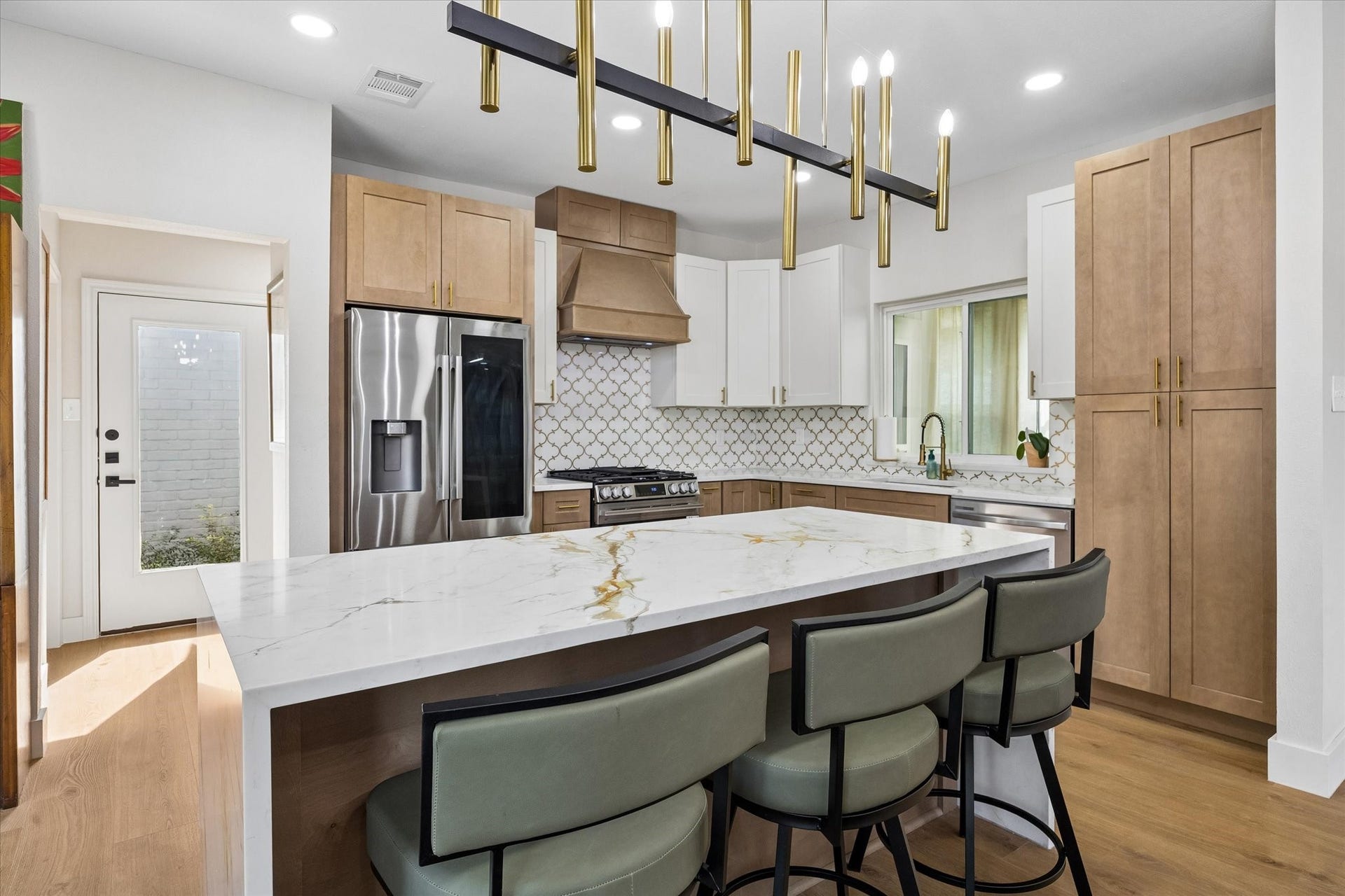 2302 Ashford Hollow Lane, Houston, TX 77077 Sleek and modern kitchen featuring a large island with stainless steel appliances, and elegant light fixtures.