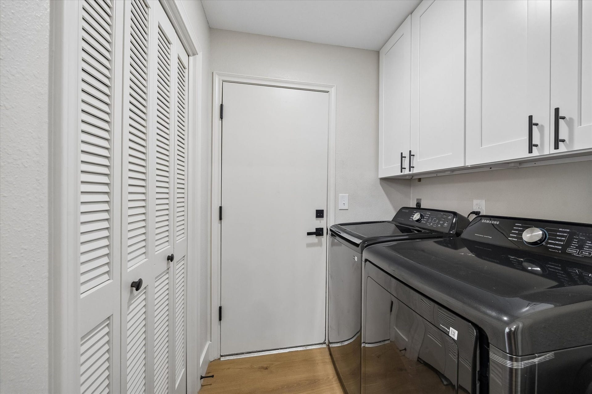 2302 Ashford Hollow Lane, Houston, TX 77077 Sleek laundry room featuring ample white cabinetry, convenient closet storage and direct access to the two car garage.