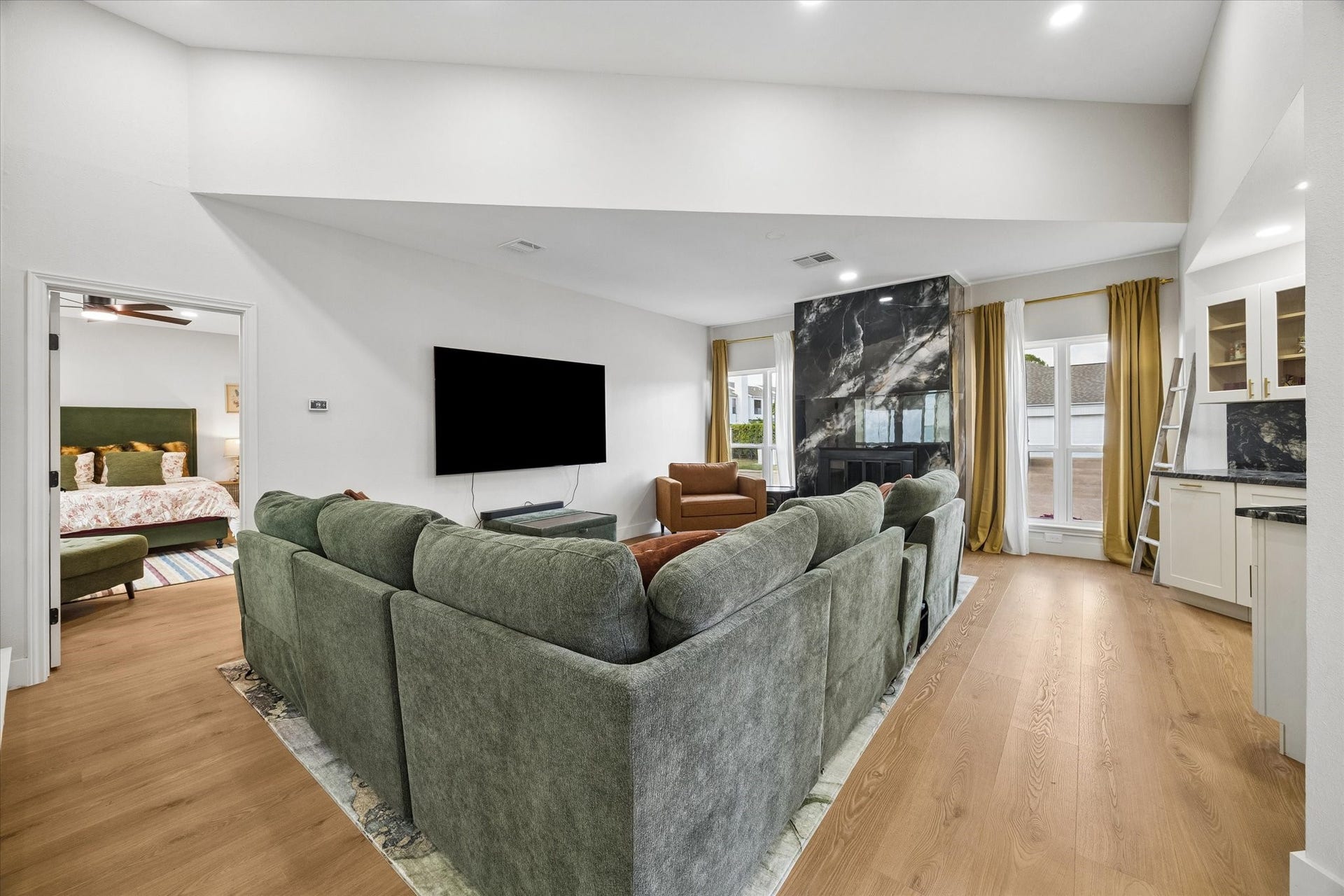 2302 Ashford Hollow Lane, Houston, TX 77077 Spacious living area with a modern fireplace, we bar area, floor to ceiling windows and high ceilings make this the perfect gathering space.