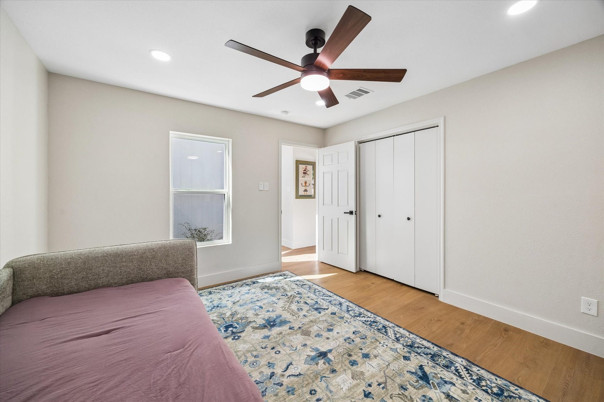 2302 Ashford Hollow Lane, Houston, TX 77077 Bright, cozy bedroom featuring a stylish ceiling fan, warm hardwood floors, and ample closet space.
