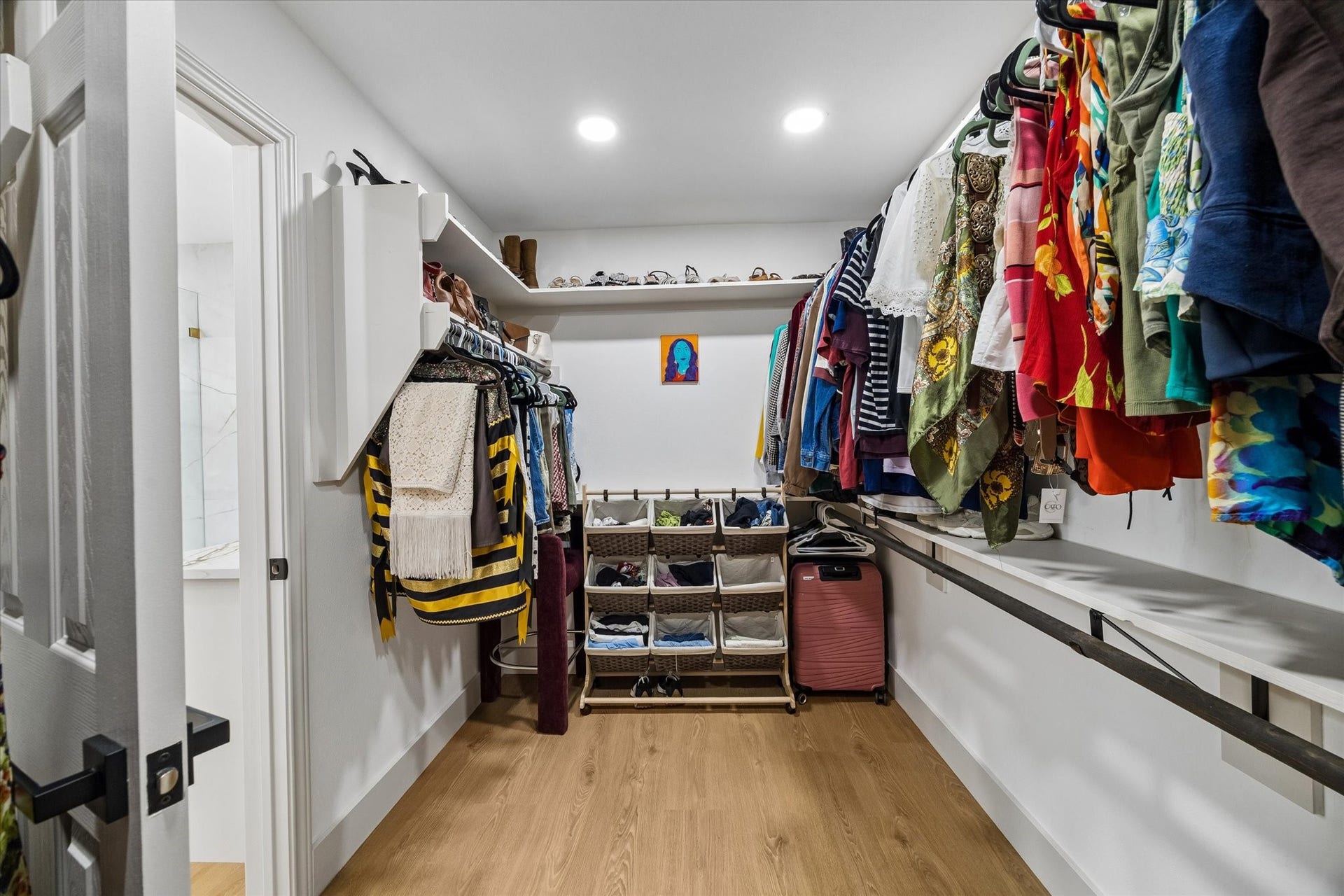 2302 Ashford Hollow Lane, Houston, TX 77077 Spacious walk-in closet with ample shelving and hanging space, featuring modern lighting and a convenient layout for easy organization.