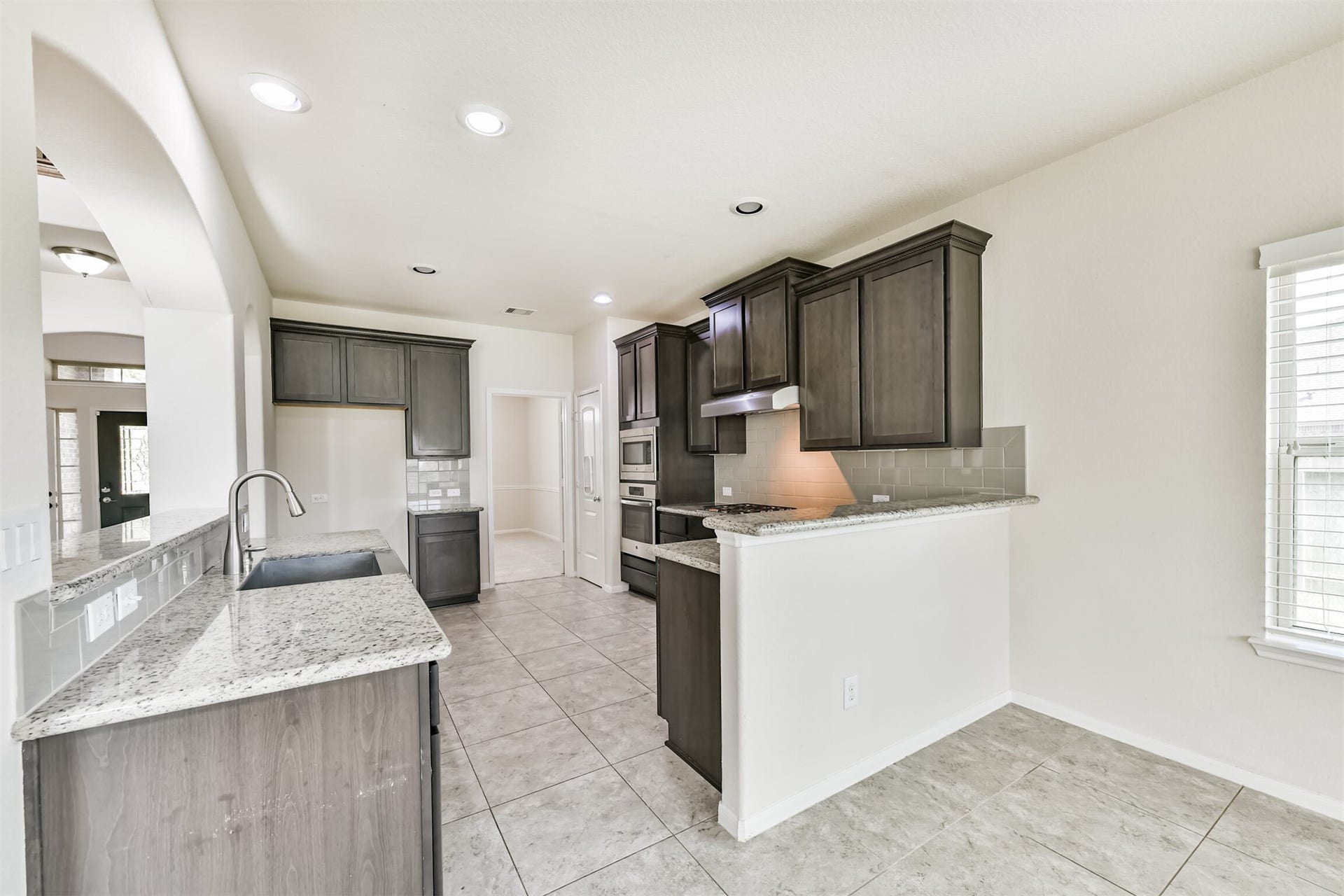 2811 Afton Drive, Pearland, TX 77581 This modern kitchen features sleek granite countertops, rich cabinetry, and a convenient open layout, perfect for entertaining and daily living.