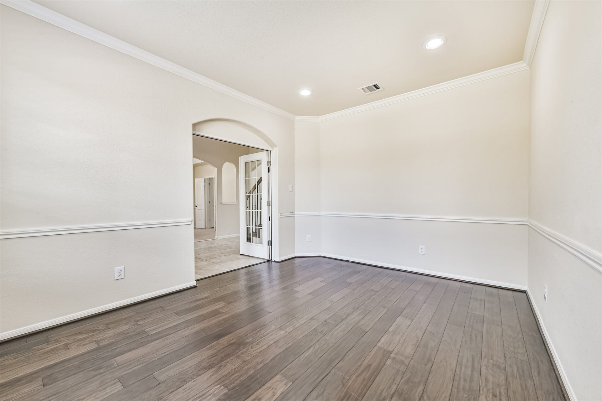 2811 Afton Drive, Pearland, TX 77581 Elegant living space featuring rich floors, crown molding, and recessed lighting, perfect for stylish entertaining and relaxation.