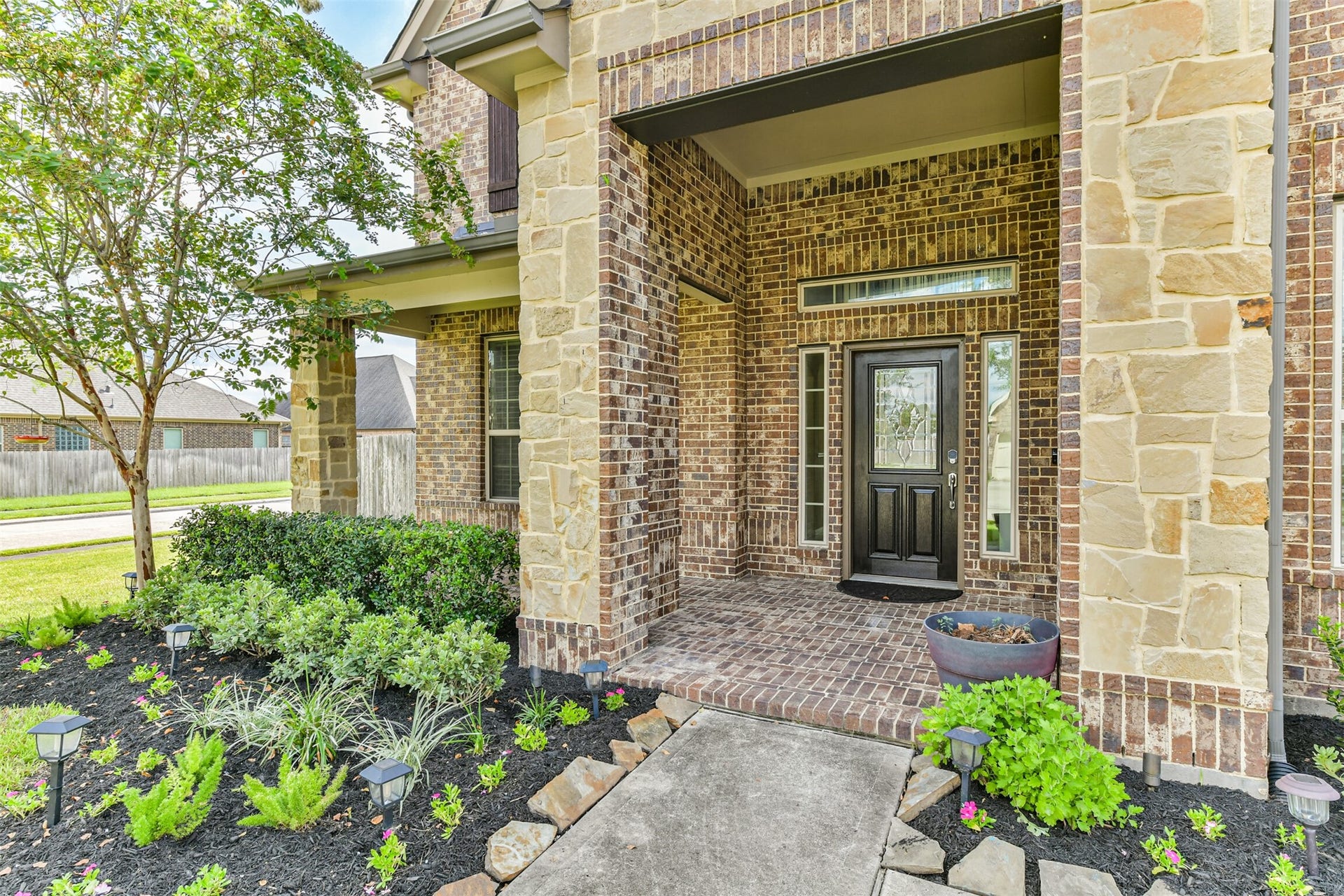 2811 Afton Drive, Pearland, TX 77581 Welcome to your new home! This inviting entry features elegant stonework and lush landscaping, setting the stage for a warm welcome.