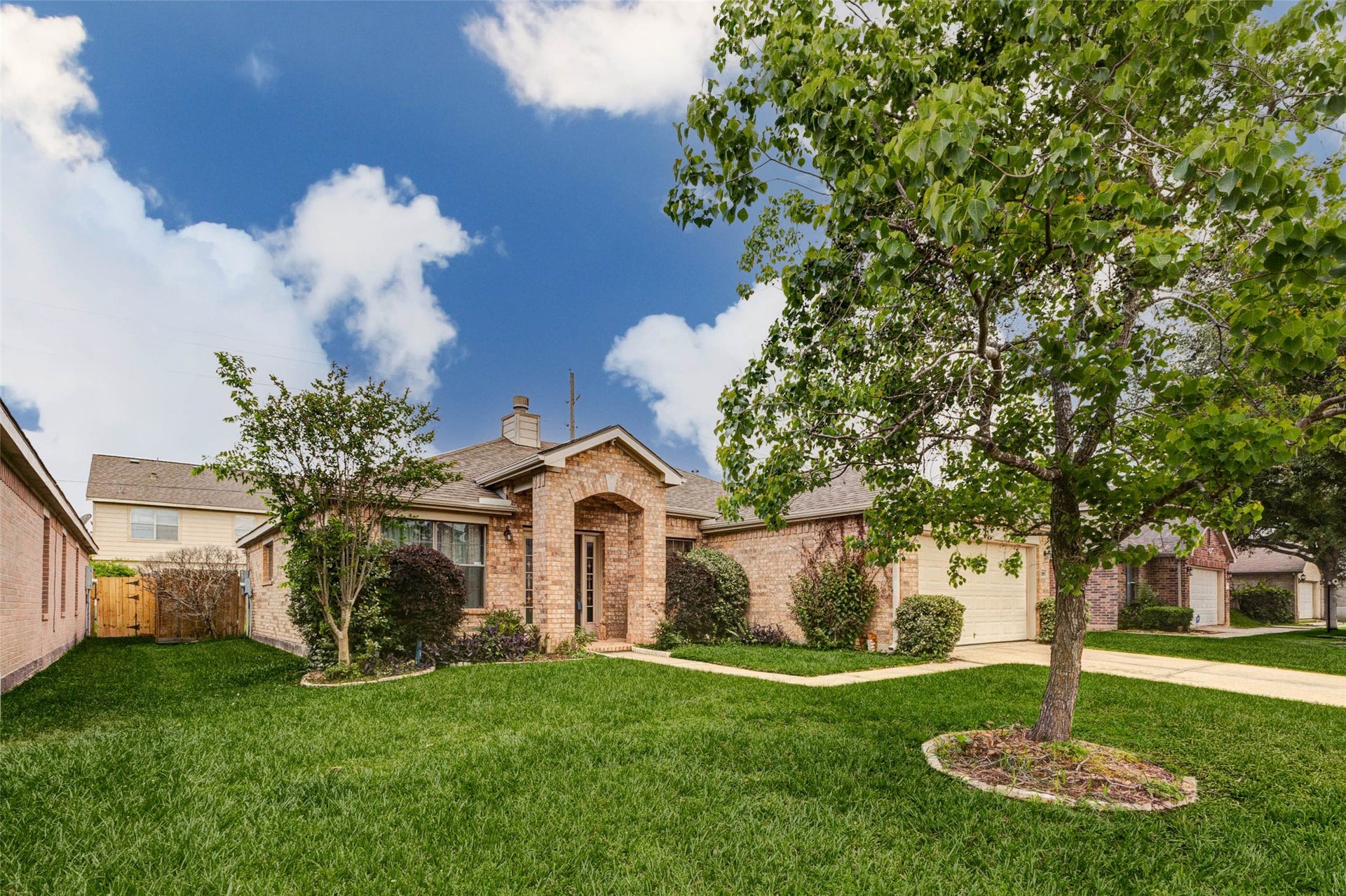 21211 Arcadia Park Lane, Humble, TX 77338 Welcoming curb appeal shines in this charming single-story brick home, framed by a lush green lawn and mature shade tree. A gently curved walkway leads to a covered arched entry, creating a warm and inviting first impression. Thoughtfully landscaped with trimmed shrubs and clean edges, the exterior reflects pride of ownership while offering a peaceful suburban setting perfect for everyday living.