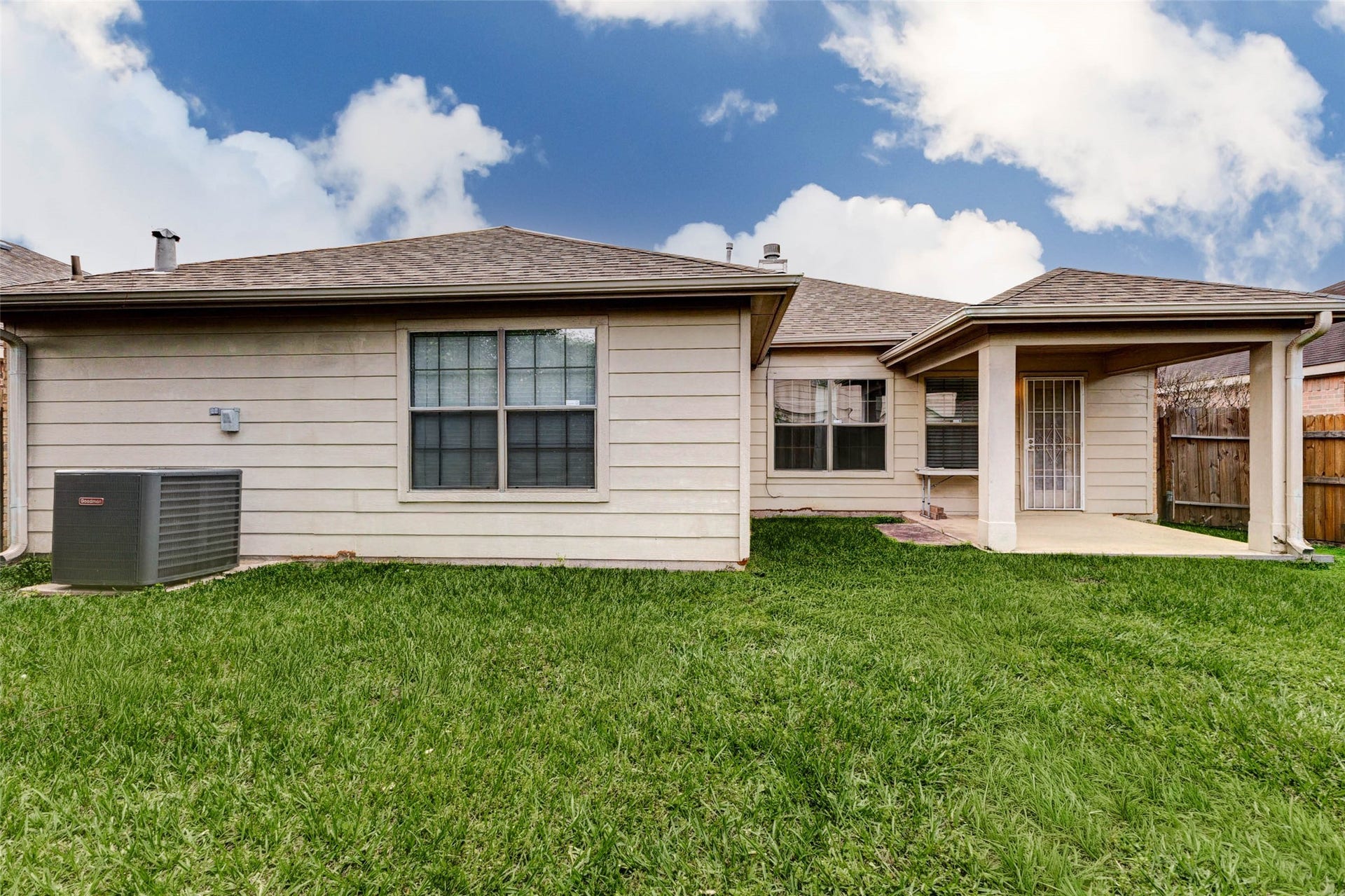 21211 Arcadia Park Lane, Humble, TX 77338 Rear exterior view highlighting the homes backyard and covered patio area. The layout offers a great balance of indoor and outdoor living, with easy access from inside the home. The spacious yard provides room to customize, whether for entertaining, gardening, or simply enjoying a quiet outdoor setting.