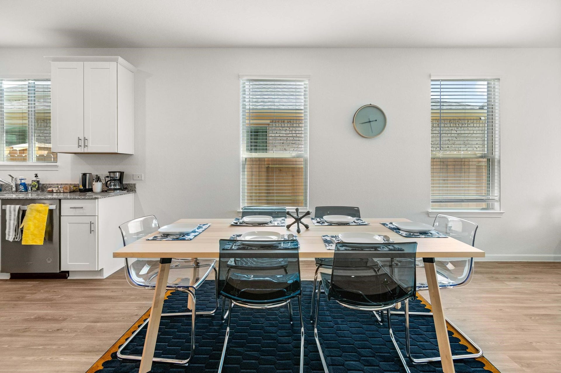 1301 Bright Hill Drive, Katy, TX 77493 Bright and inviting dining area with a modern table setting, adjacent to a sleek kitchen featuring white cabinetry and stainless steel appliances.