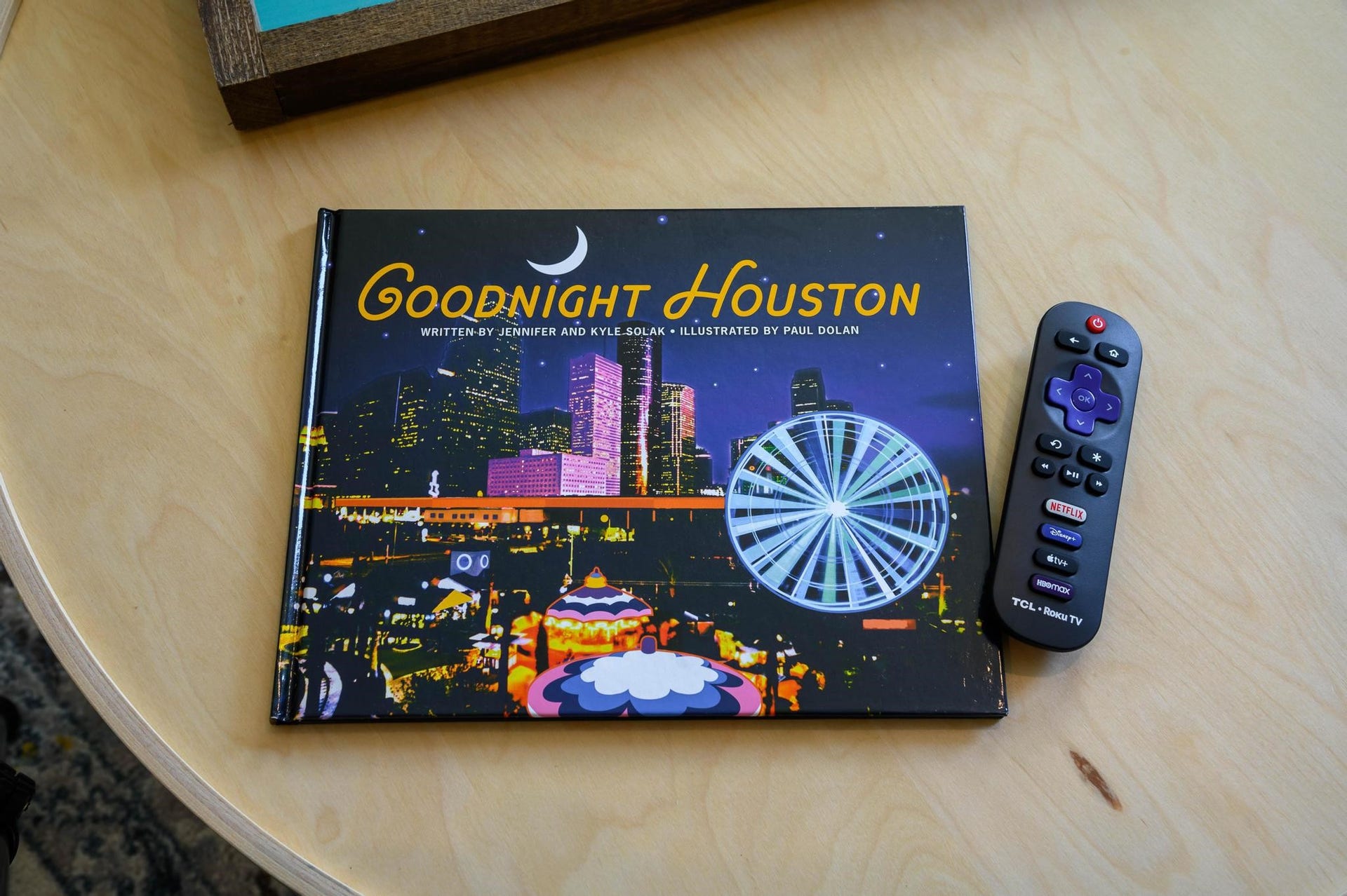 1301 Bright Hill Drive, Katy, TX 77493 A cozy reading nook features the book "Goodnight Houston" on a light wood table, paired with a convenient remote control for relaxing evenings.
