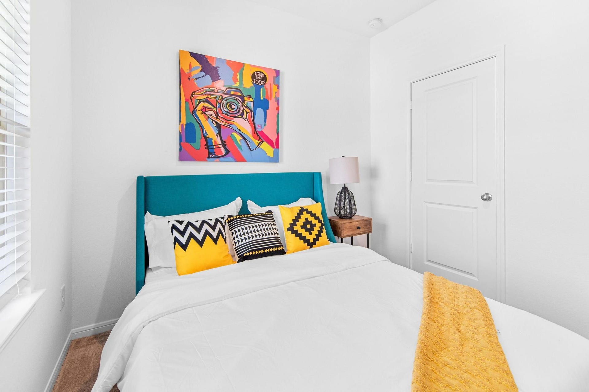 1301 Bright Hill Drive, Katy, TX 77493 Bright and inviting bedroom featuring a vibrant teal headboard, colorful artwork, and stylish geometric pillows.