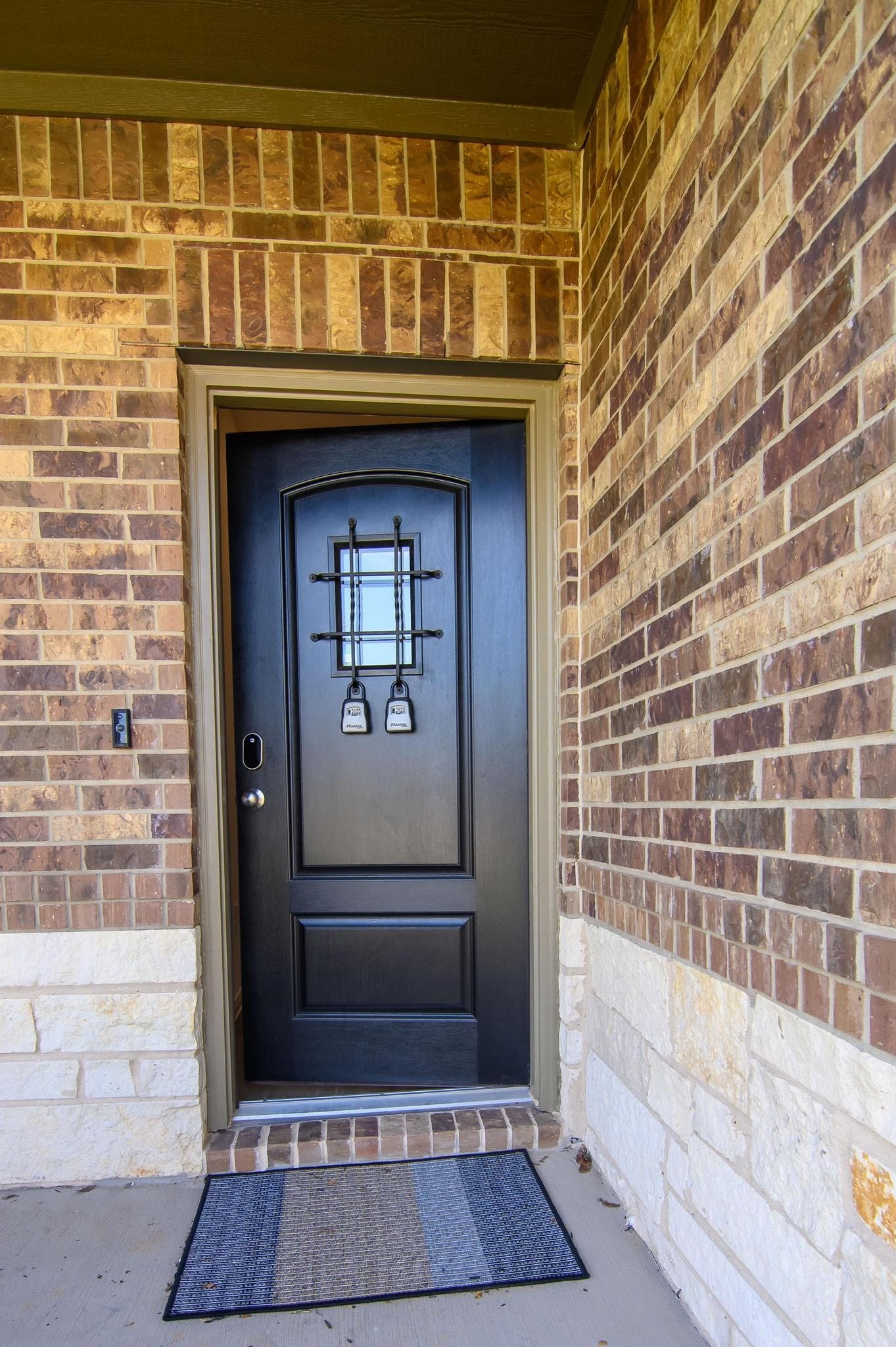 1301 Bright Hill Drive, Katy, TX 77493 Charming brick entryway featuring a stylish black front door with decorative accents and a welcoming doormat.