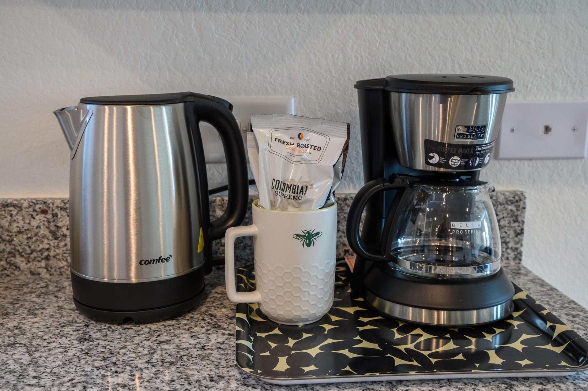 1301 Bright Hill Drive, Katy, TX 77493 Modern kitchen setup featuring a sleek stainless steel kettle and coffee maker on a stylish granite countertop, perfect for your morning routine.