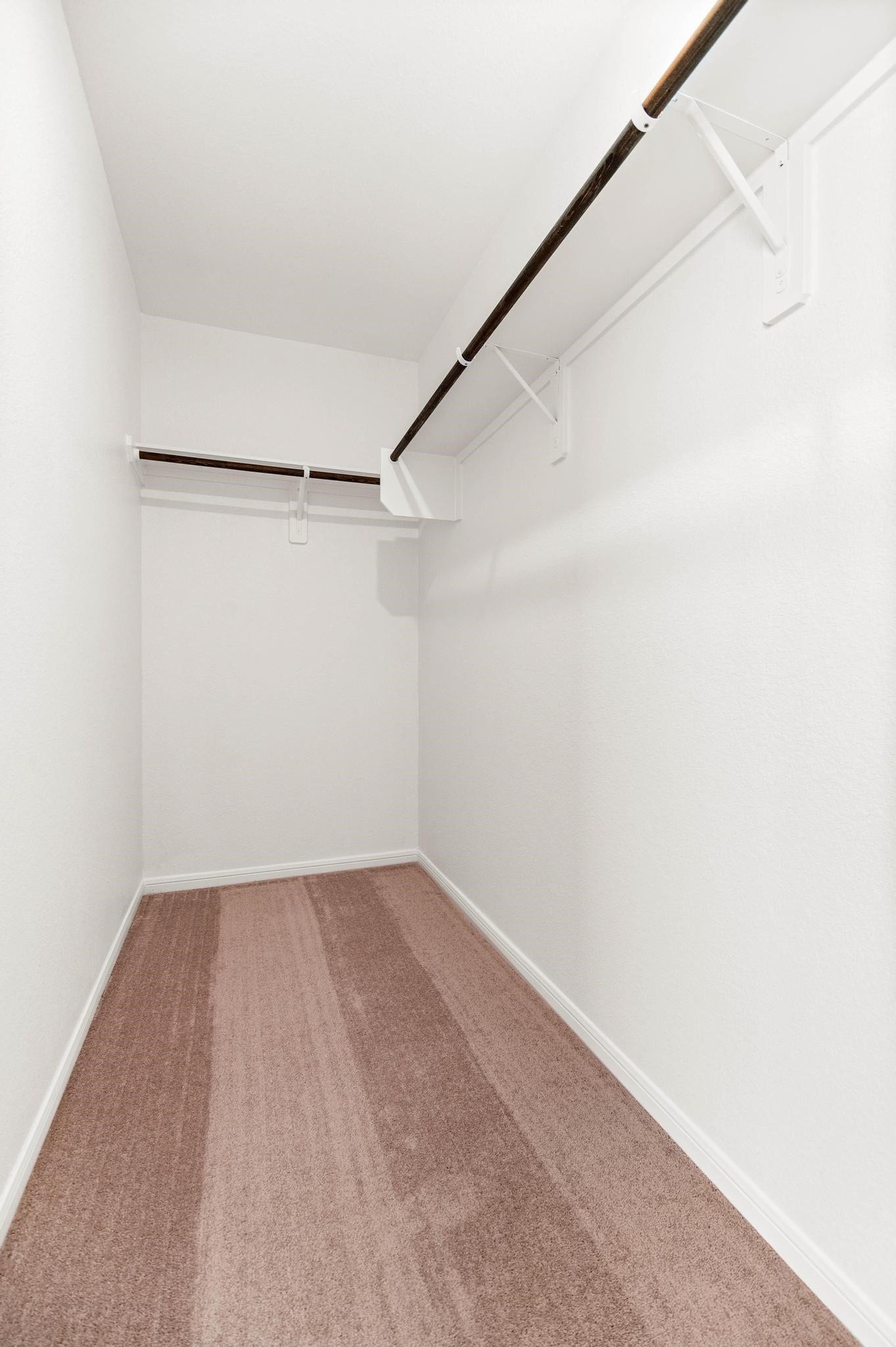 1301 Bright Hill Drive, Katy, TX 77493 Spacious walk-in closet with double hanging rods and plush carpet, perfect for organizing your wardrobe.