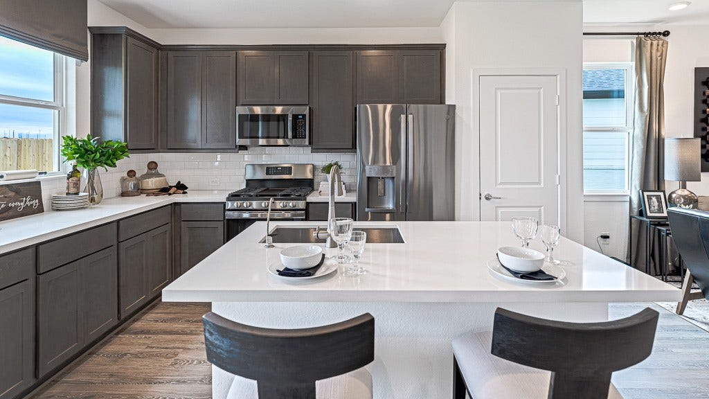 7338 Grand Mason Drive, Cypress, TX 77433 Well laid out kitchen designed for efficiency, convenience, and beauty, has ample counter/cabinet space and a walk-in pantry. Modern dark gray cabinets look sharp with white quartz counters and subway tile backsplash.