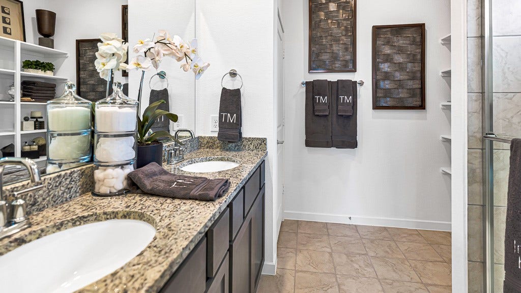 7338 Grand Mason Drive, Cypress, TX 77433 Primary ensuite has double vanities with modern silver fixtures and black cabinetry.