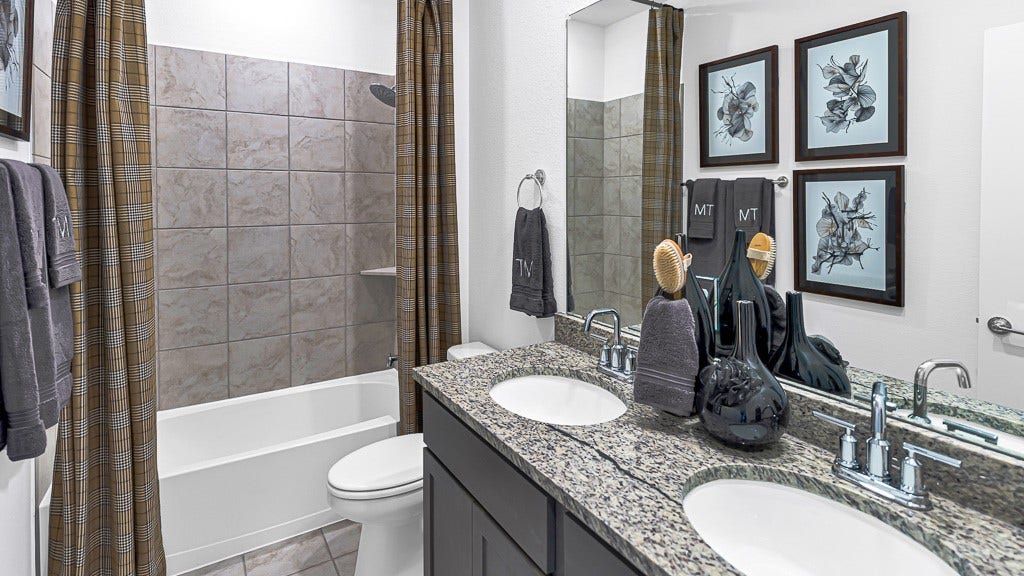 7338 Grand Mason Drive, Cypress, TX 77433 Bathroom 2 has a modern double sink vanity with striking black cabinetry, crisp white undermount sinks, tied together with gorgeous granite counters and silver fixtures. Tub/Shower Combo.