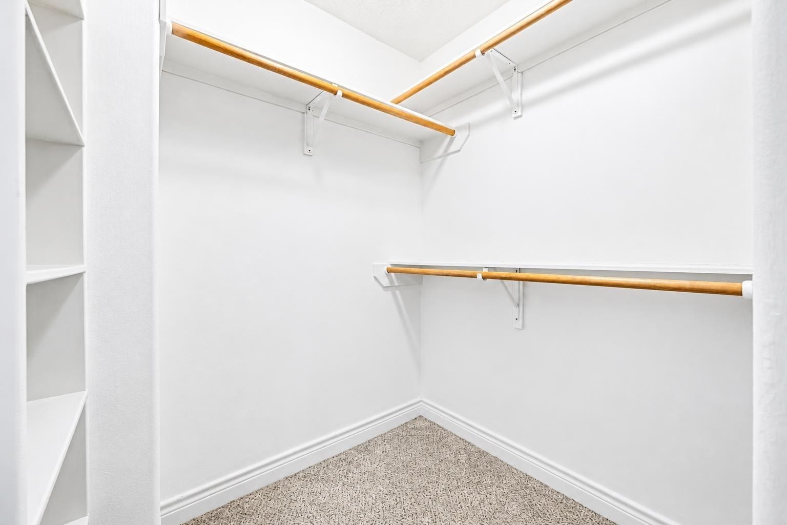 2604 Chenevert Street, Houston, TX 77004 The primary bedroom first walk in closet with hanging racks and build in shelving