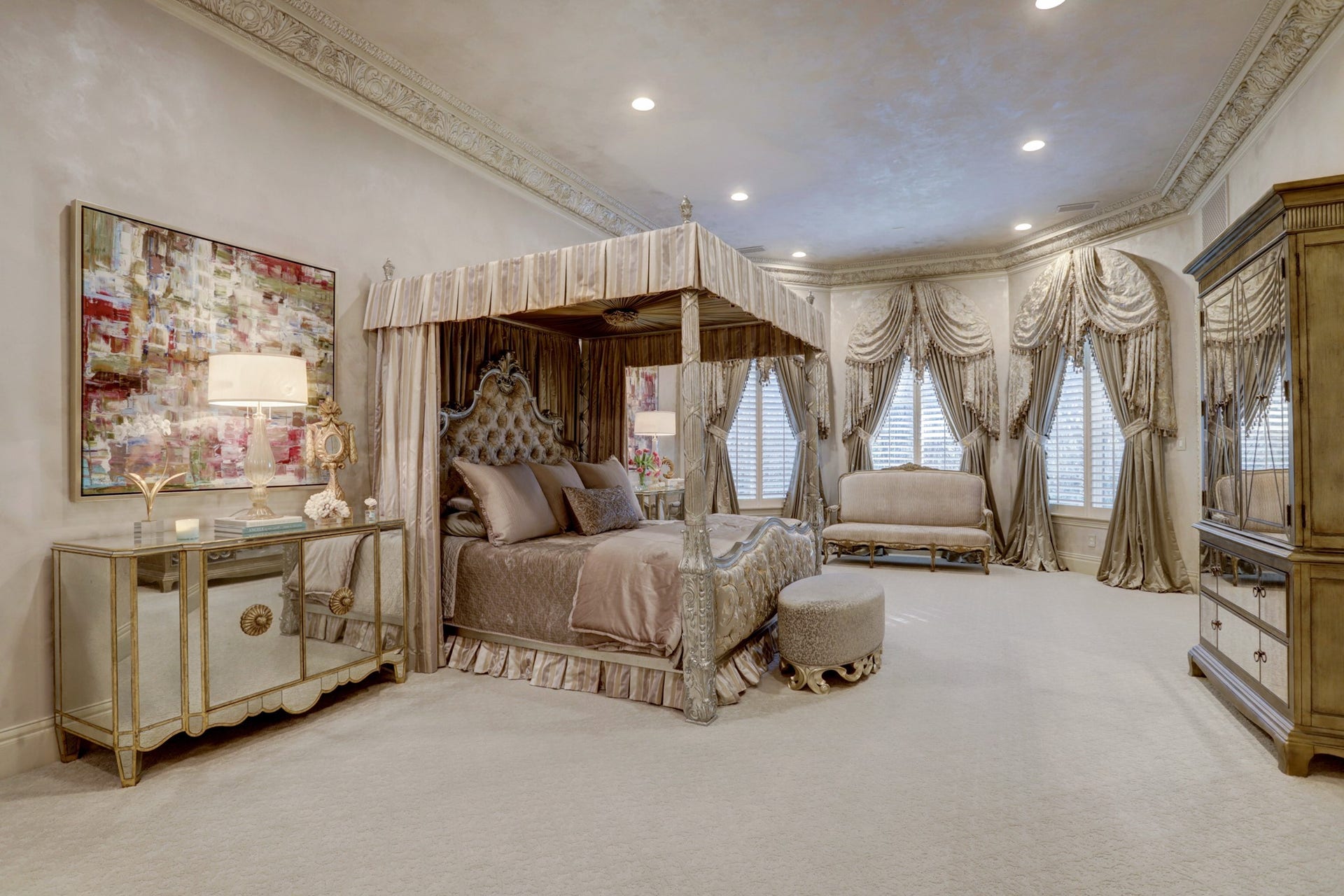 36 Saddlebrook Court, Tomball, TX 77375 The expansive primary suite exudes elegance, showcasing custom crown molding, a spacious layout that includes a sitting area, large bay windows, and luxurious custom drapes all wrapped in gorgeous venetian plaster walls.