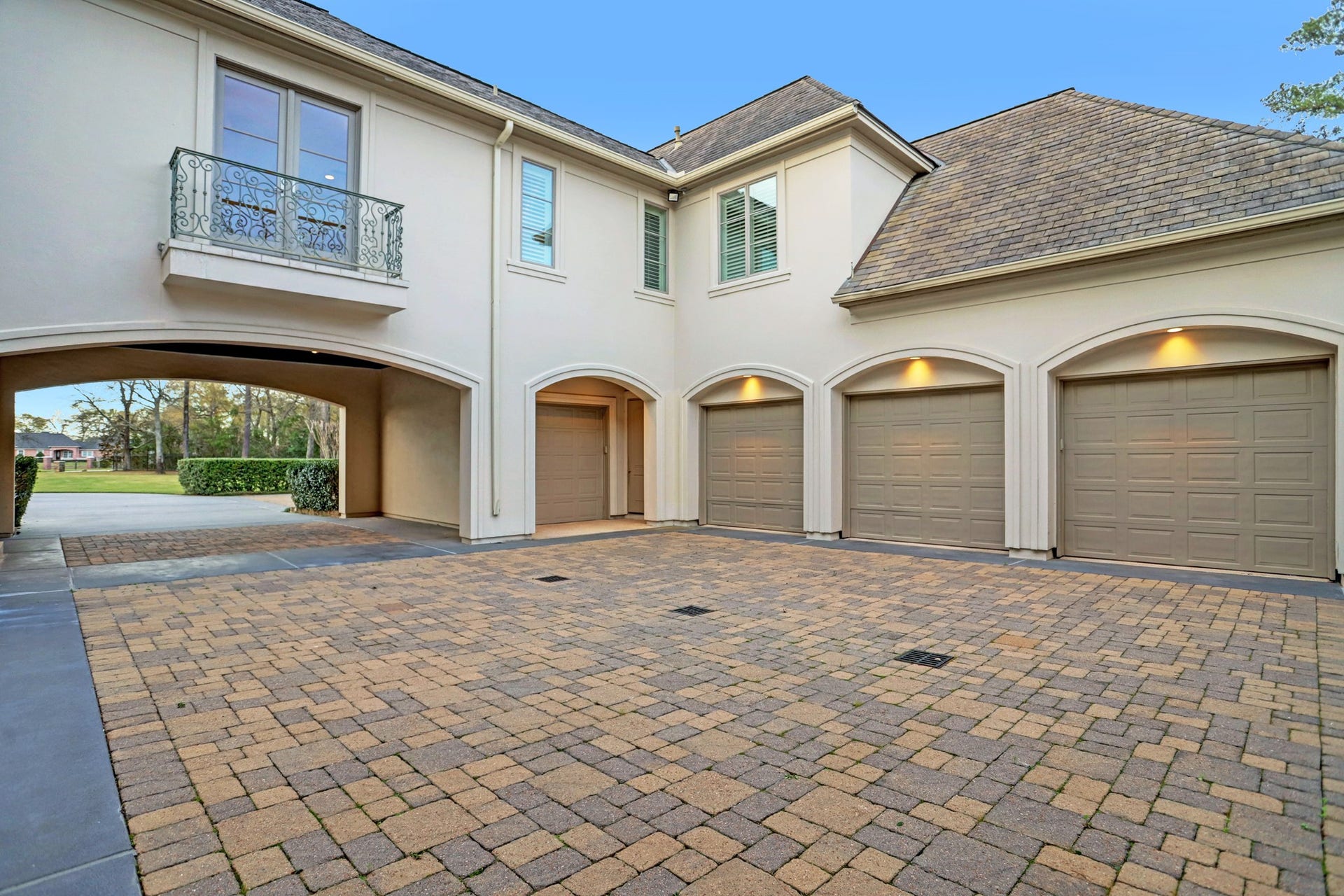36 Saddlebrook Court, Tomball, TX 77375 A spacious motor court, accessible through the porte-cochere, leads to an expansive garage area, offering ample space for parking and storage.