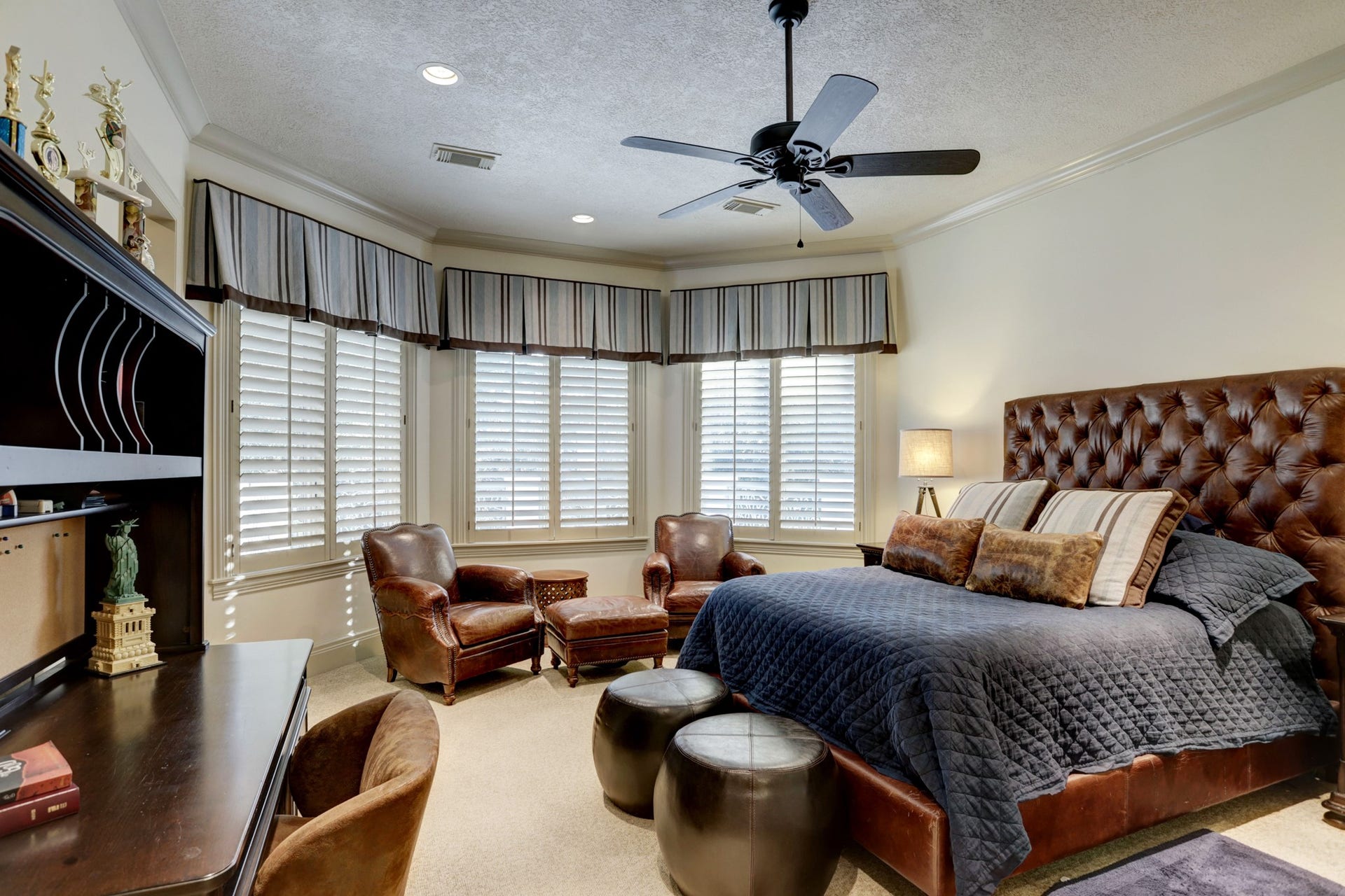 36 Saddlebrook Court, Tomball, TX 77375 This spacious secondary bedroom features a charming bay window, plantation shutters, ample room for relaxation and privacy, an ensuite bath, and a generous walk-in closet.